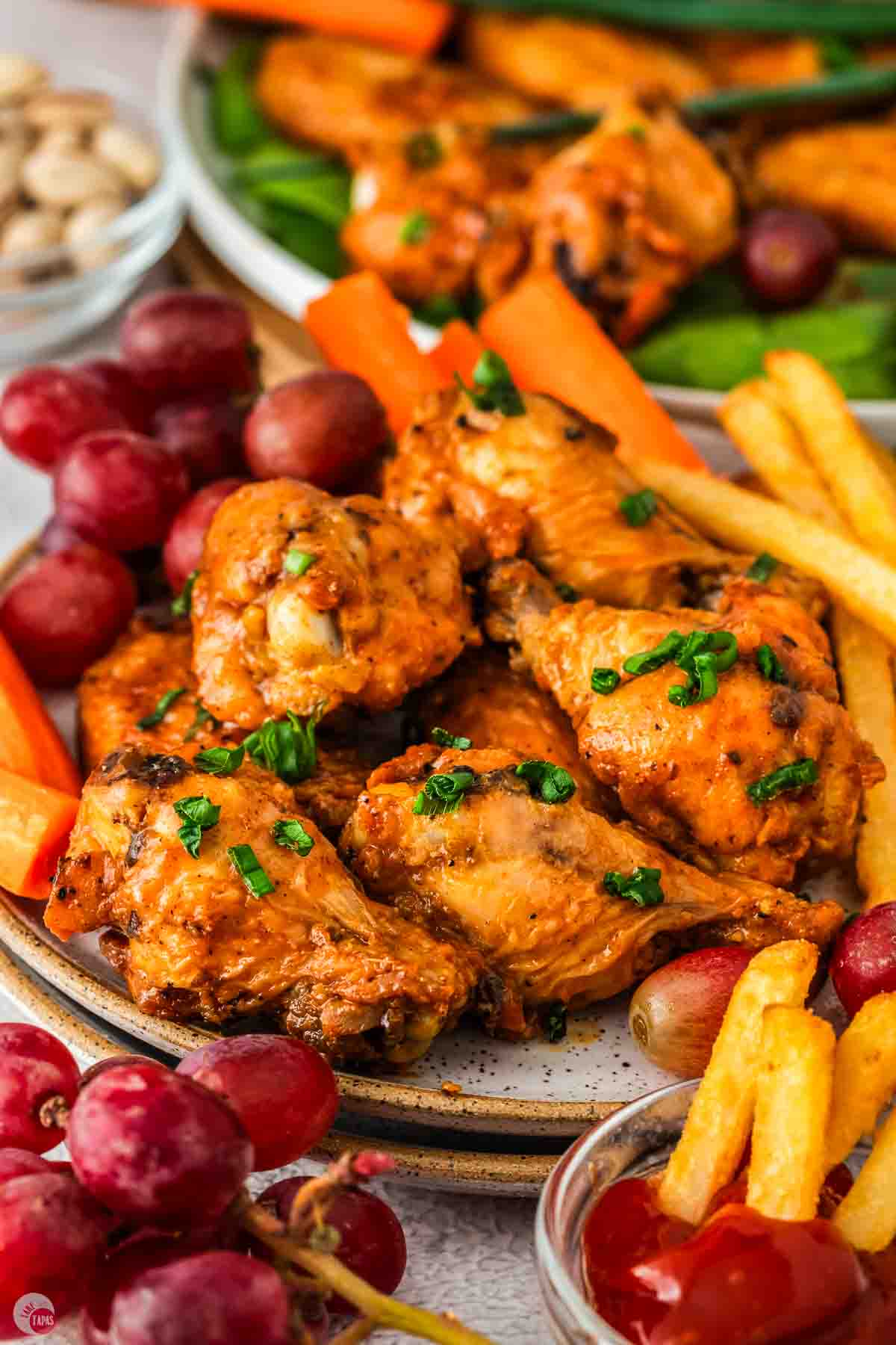 plate of wings with carrot sticks and grapes