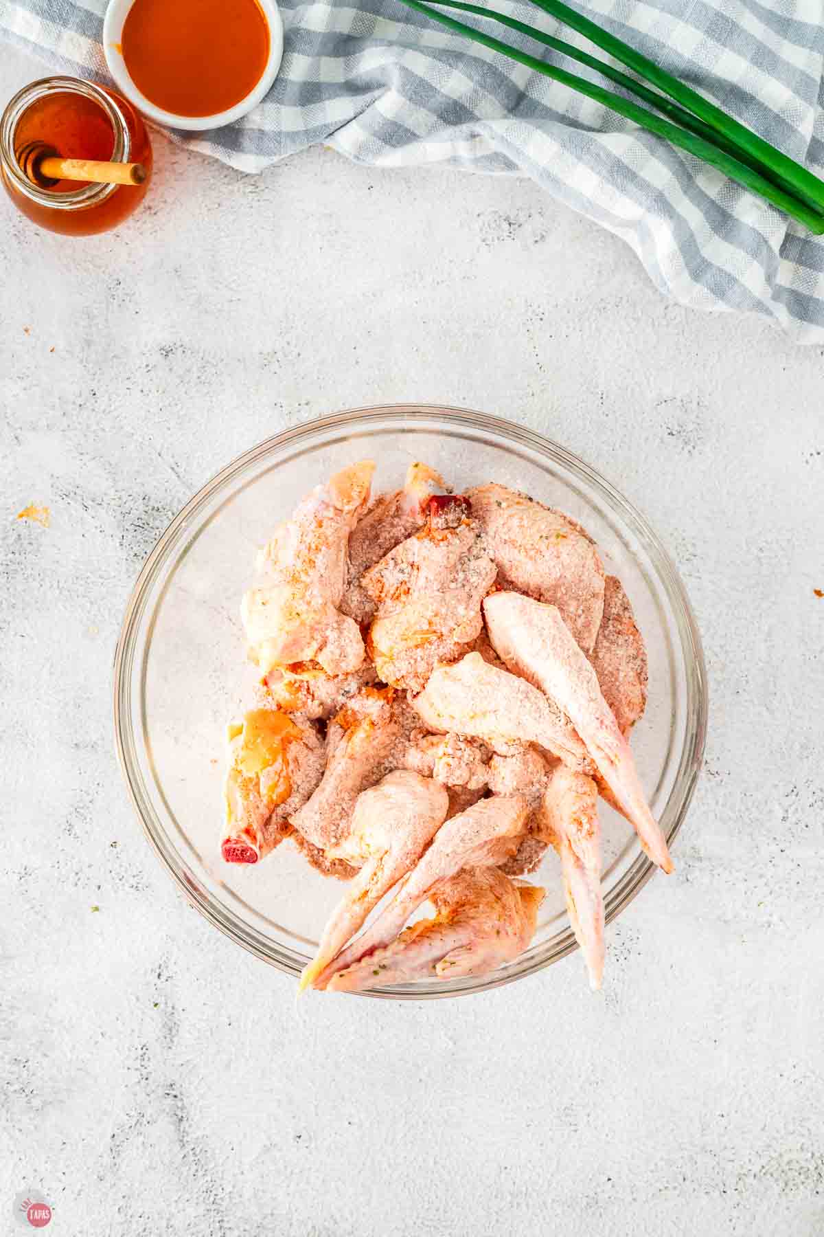 cut, raw chicken wings in a clear bowl