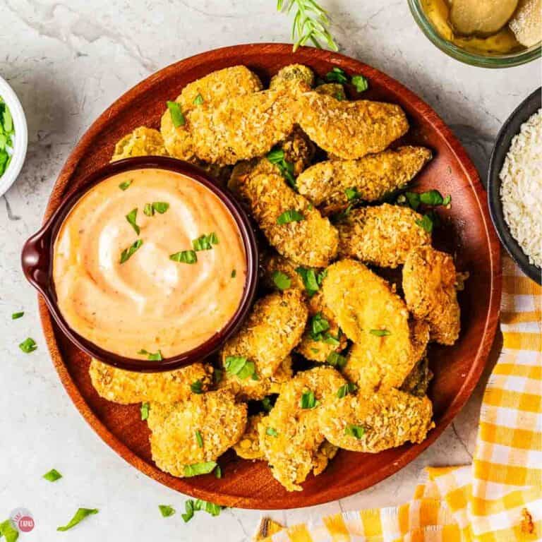 red plate with fried pickles and a small bowl of dip