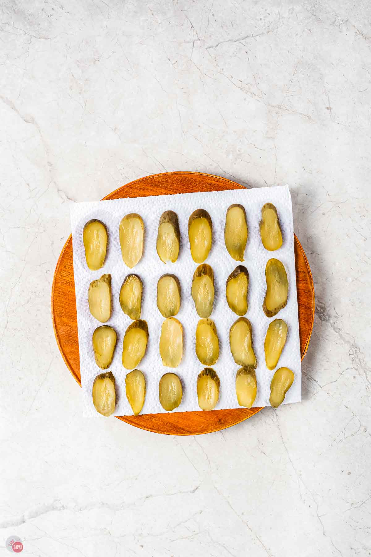pickle slices frying on a paper towel-lined plate