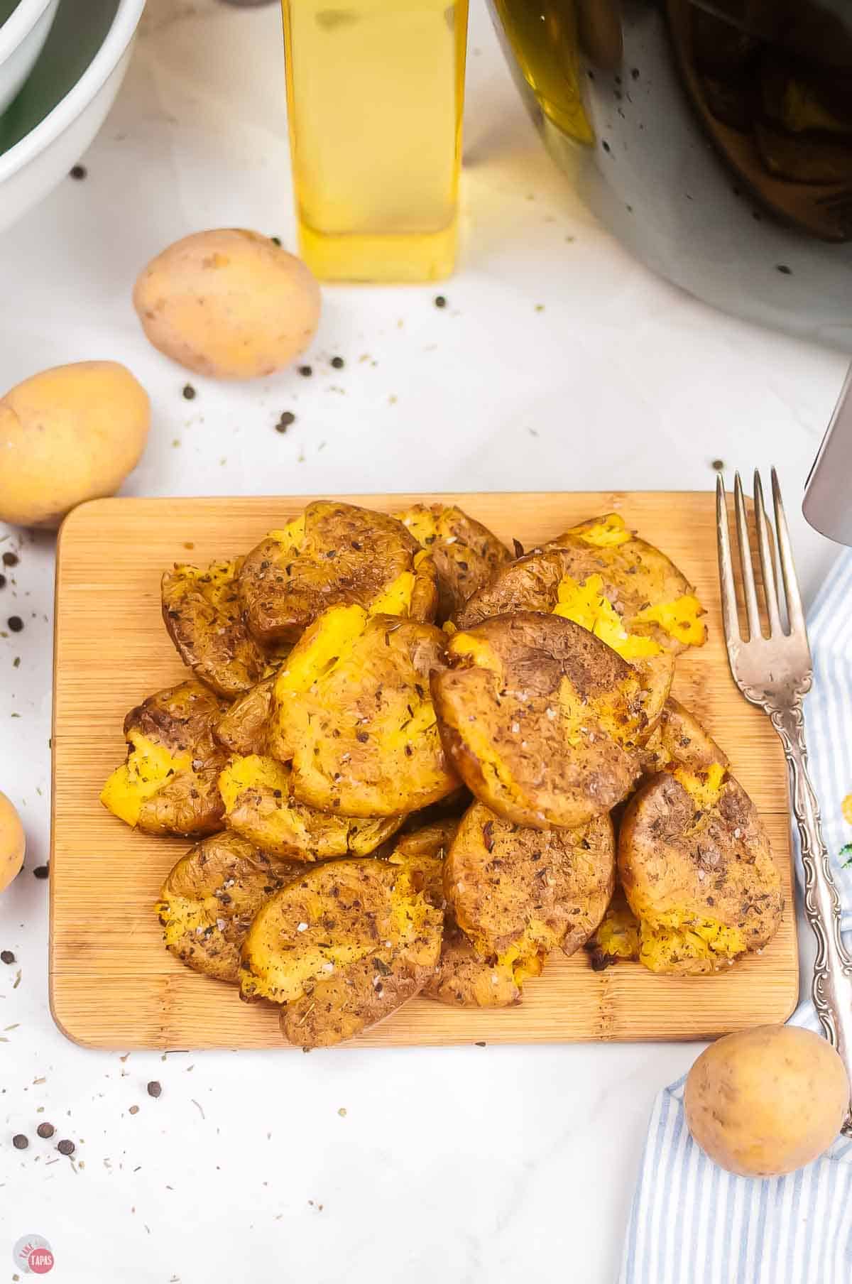 wood board topped with smashed potatoes