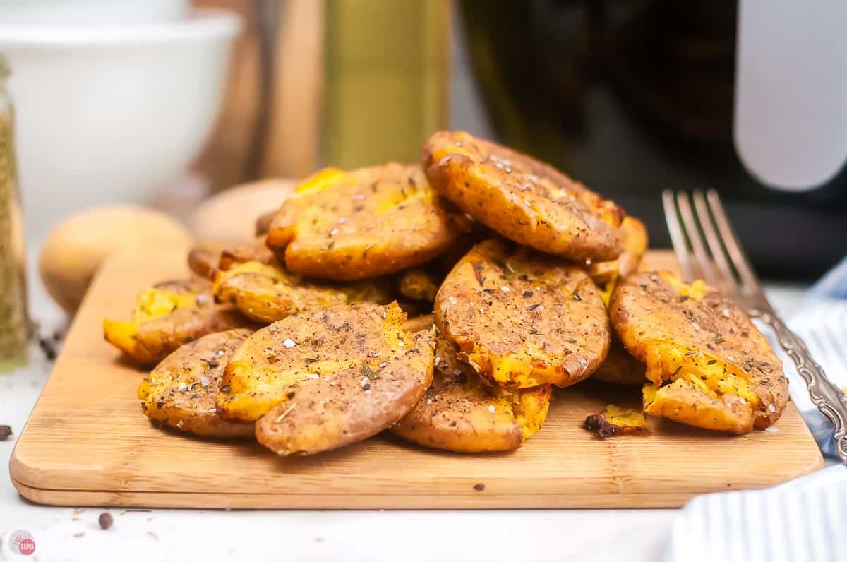 smashed potatoes on a wood cutting board