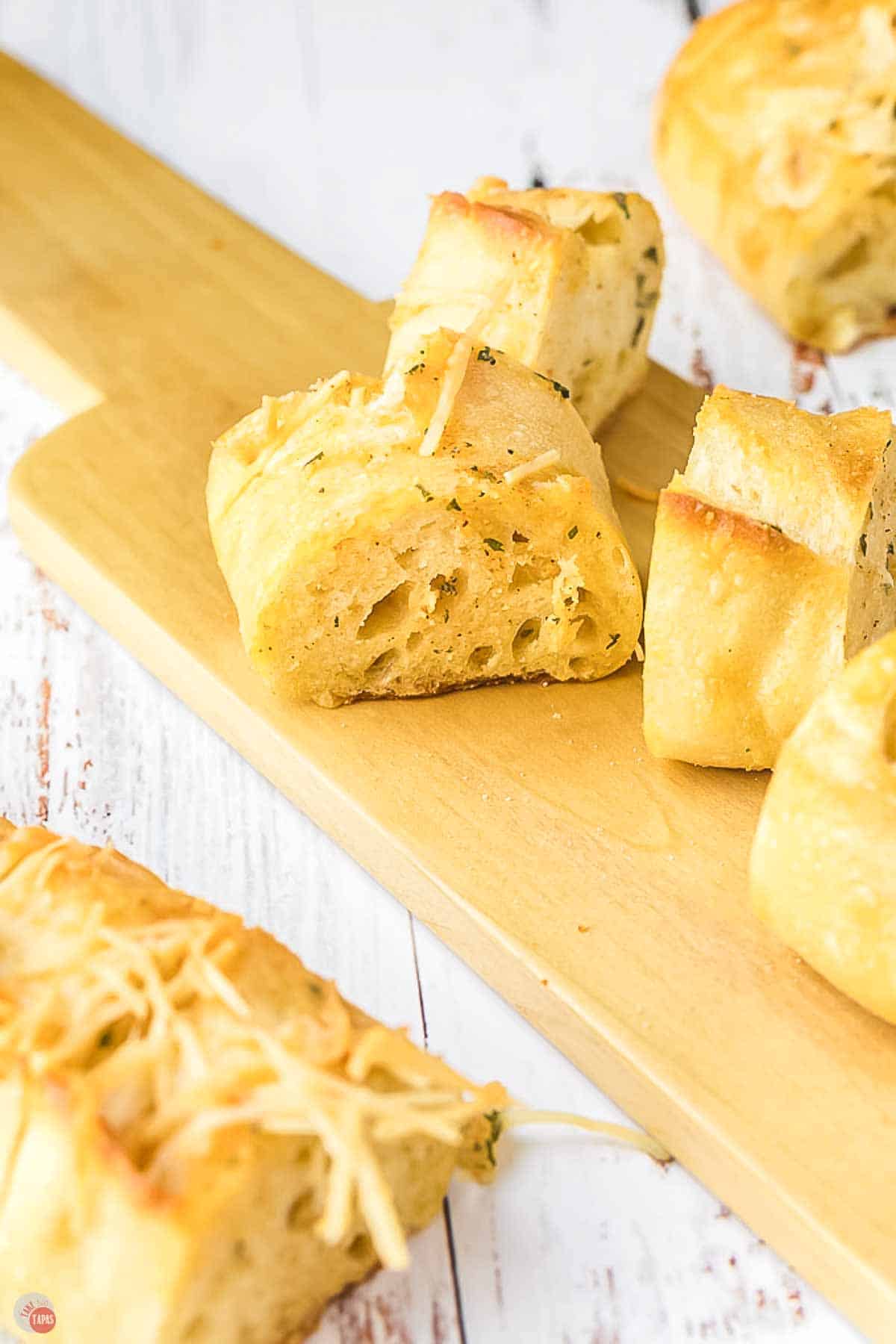 slices of garlic bread on a thin cutting board