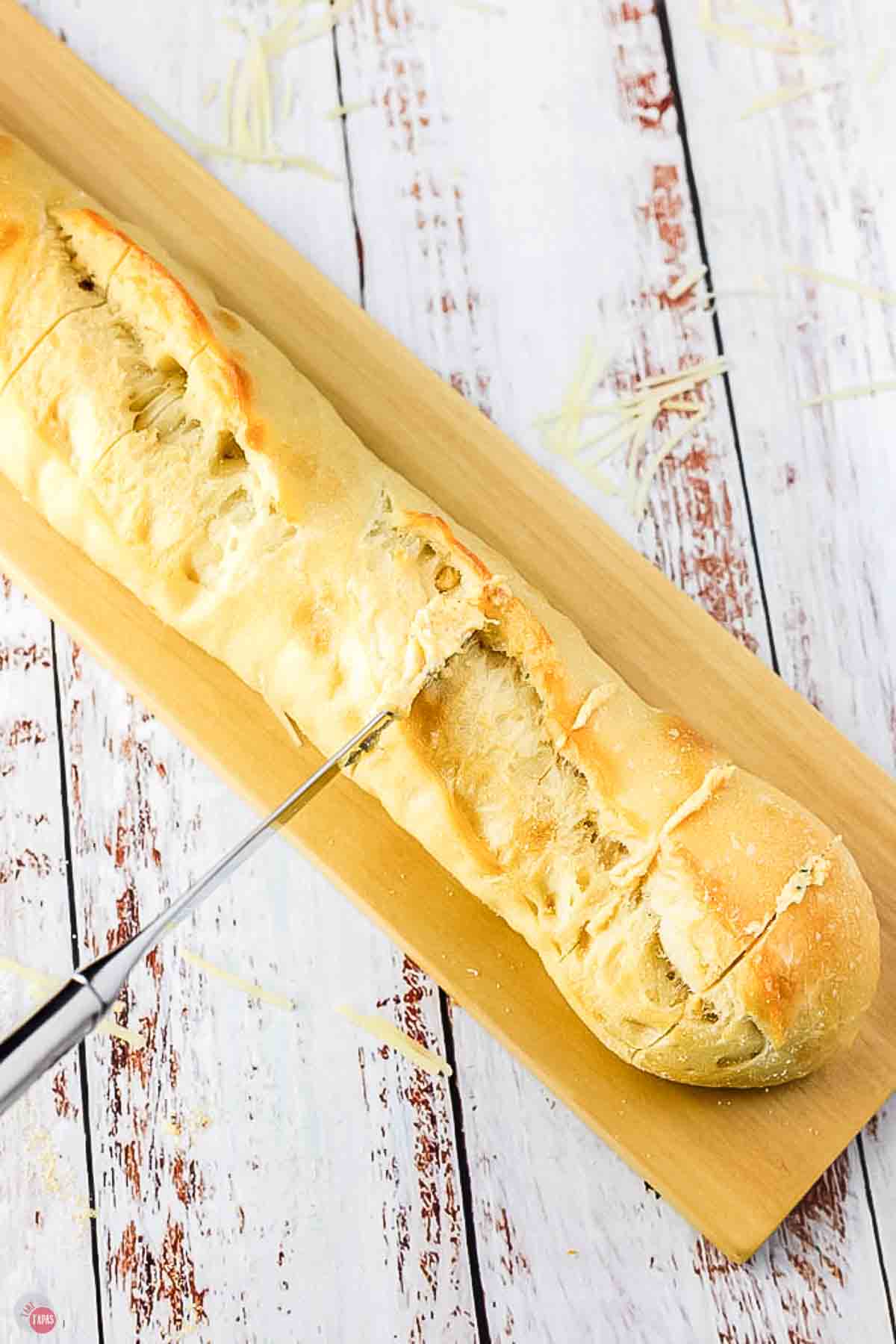 knife cutting a loaf of bread