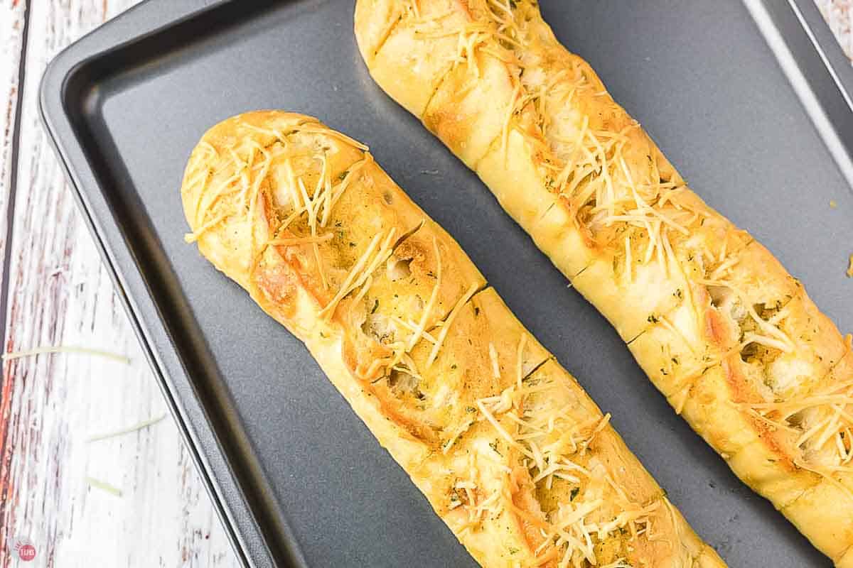 baking sheet with loaves of garlic bread on it