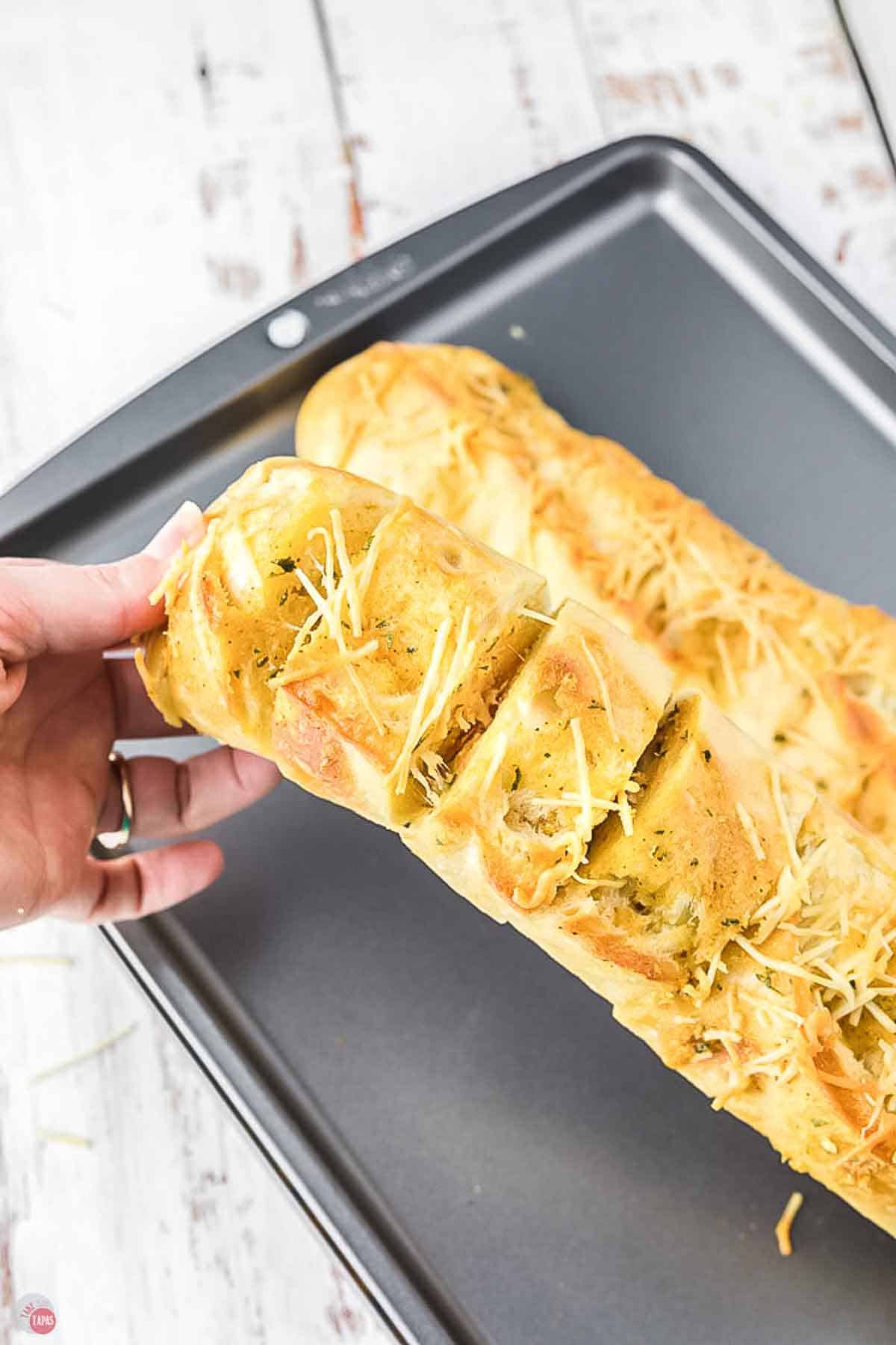 hand bending a sliced loaf of bread