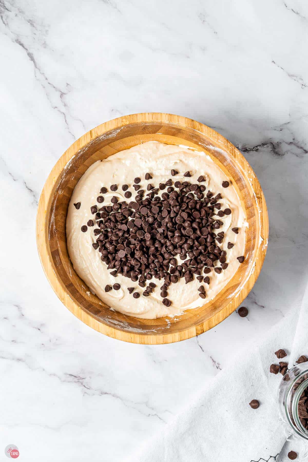 wood bowl of creamy dessert dip topped with mini chocolate chips