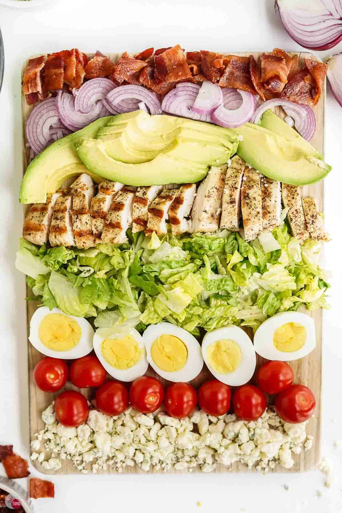 salad ingredients chopped and laid out on a chopping board