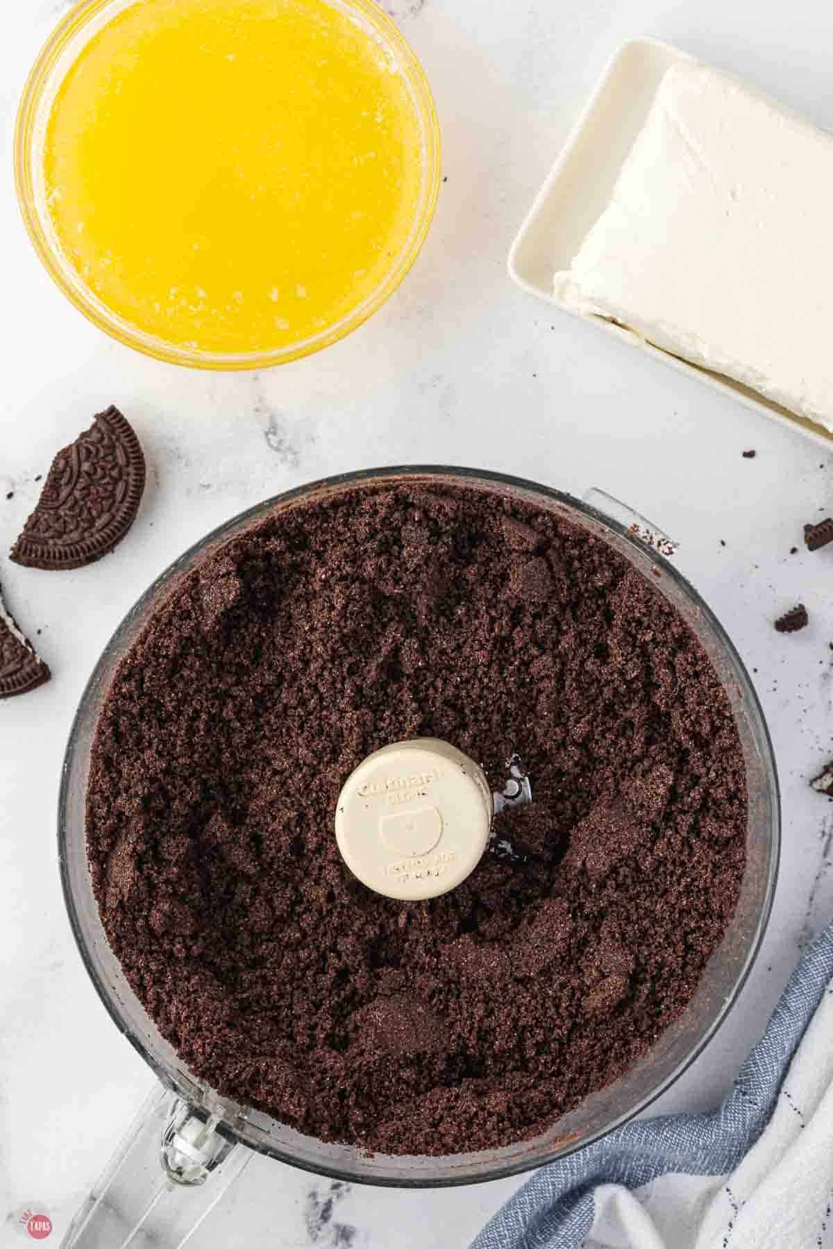 chocolate cookies being crushed in a food processor