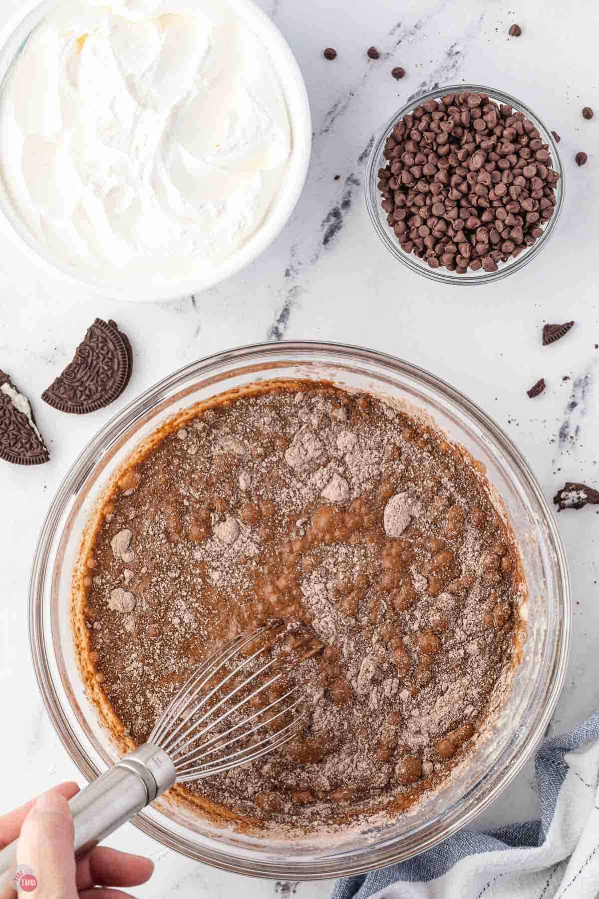 chocolate pudding being whisked in a clear bowl