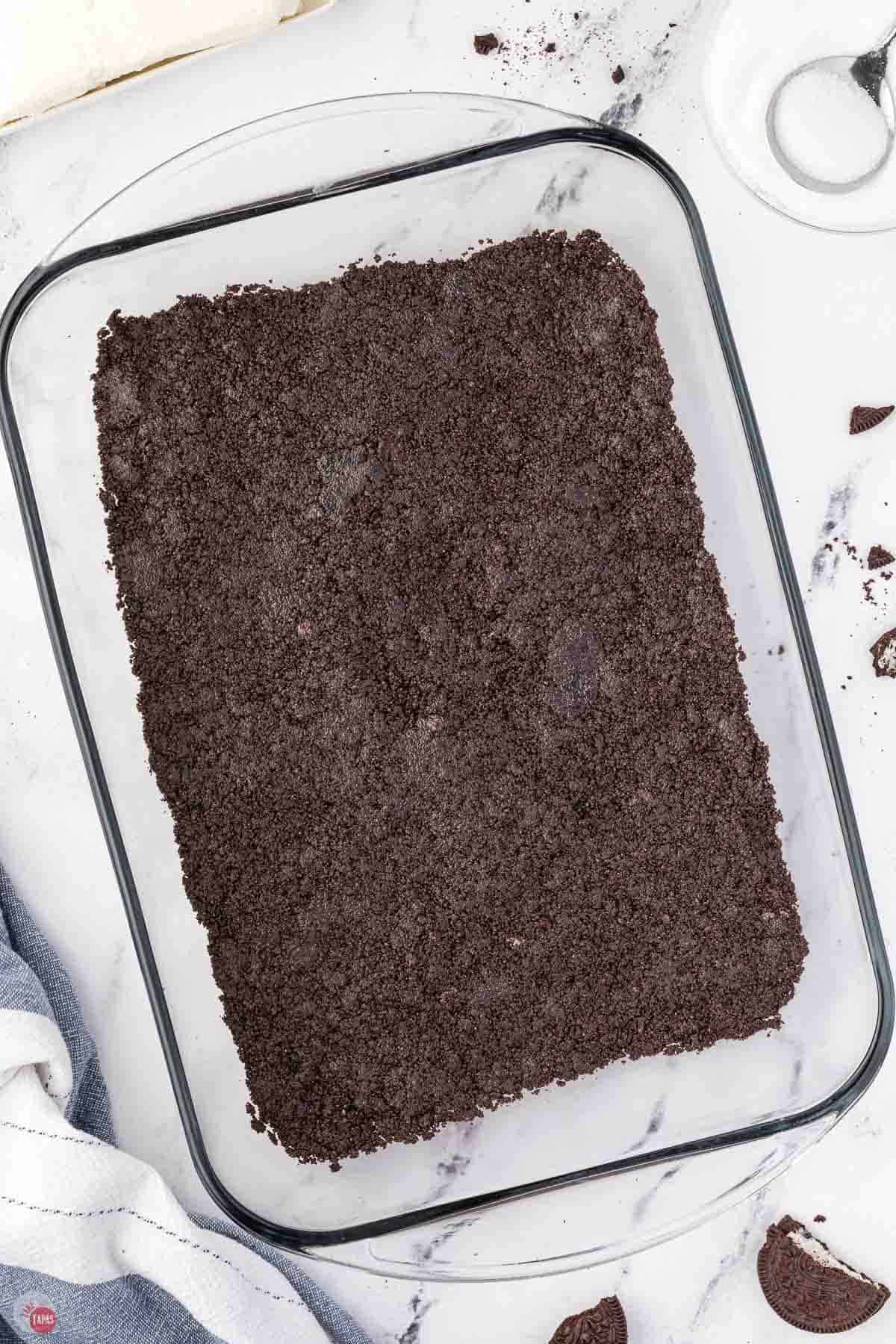 crushed oreo cookies and melted butter pressed into the bottom of a clear 9x13 dish