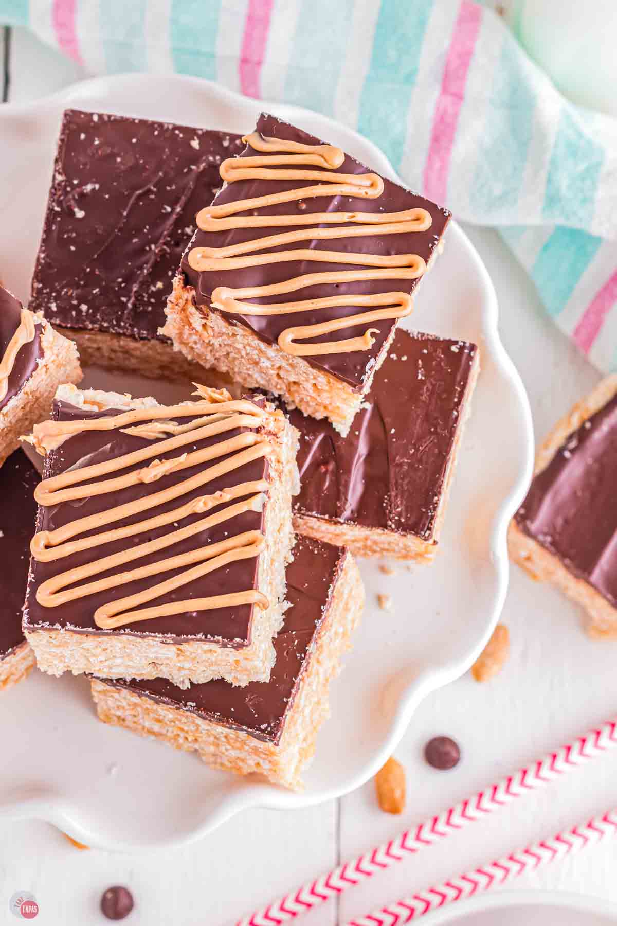 close up of overhead shot of chocolate peanut butter rice krispies treats on a white cake plate