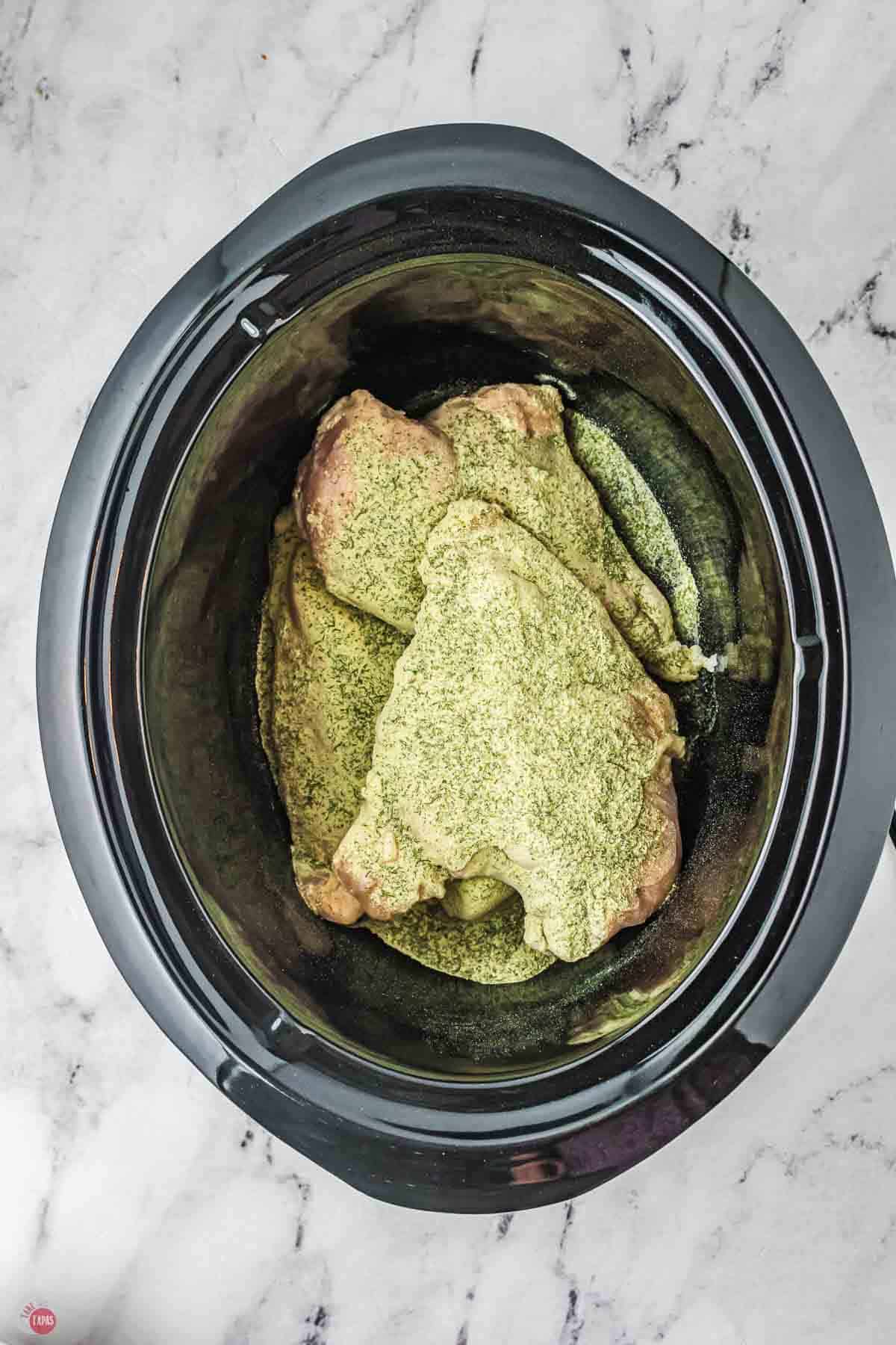 chicken breasts in a slow cooker topped with ranch seasoning