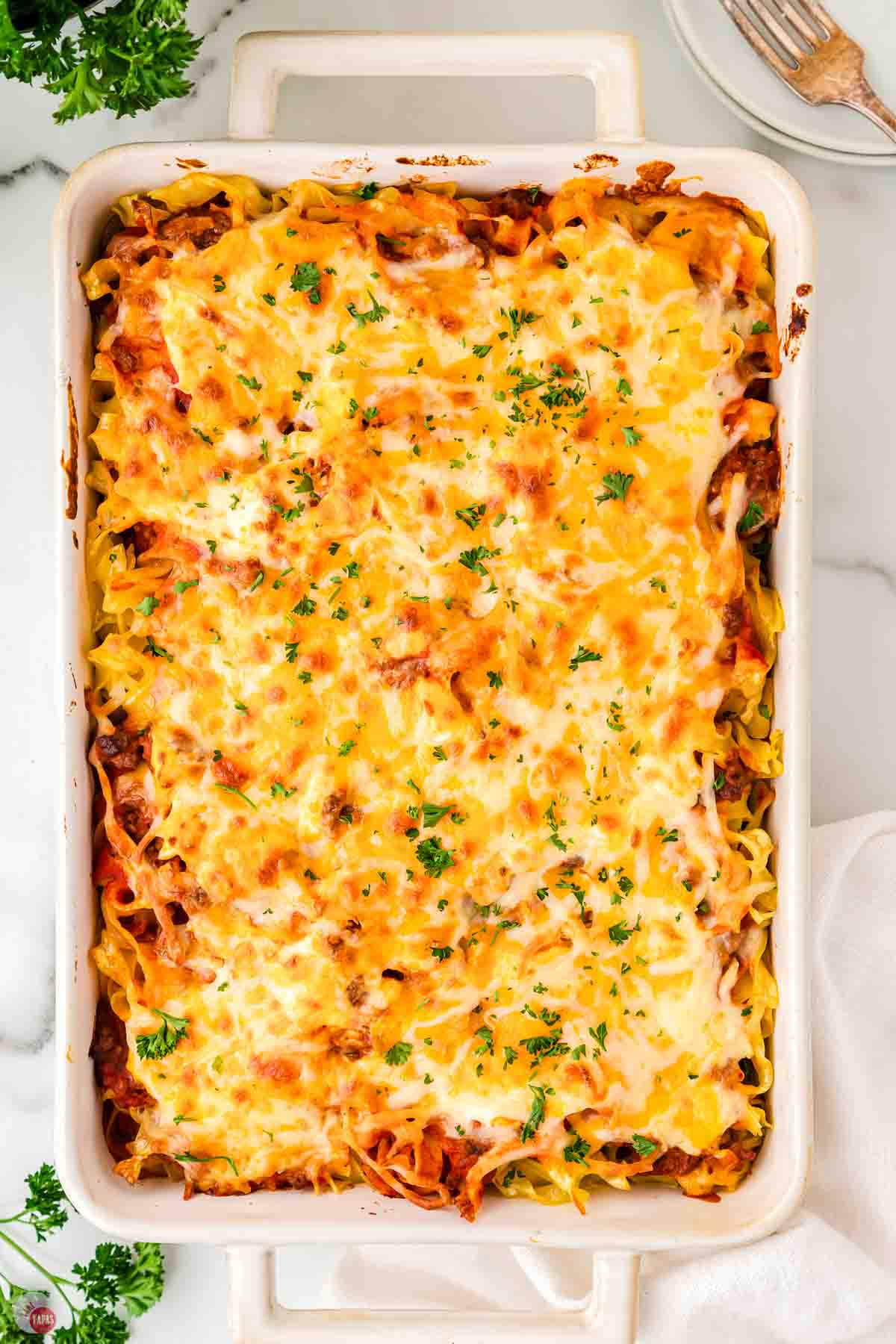 baked casserole topped with melted cheese in a white dish