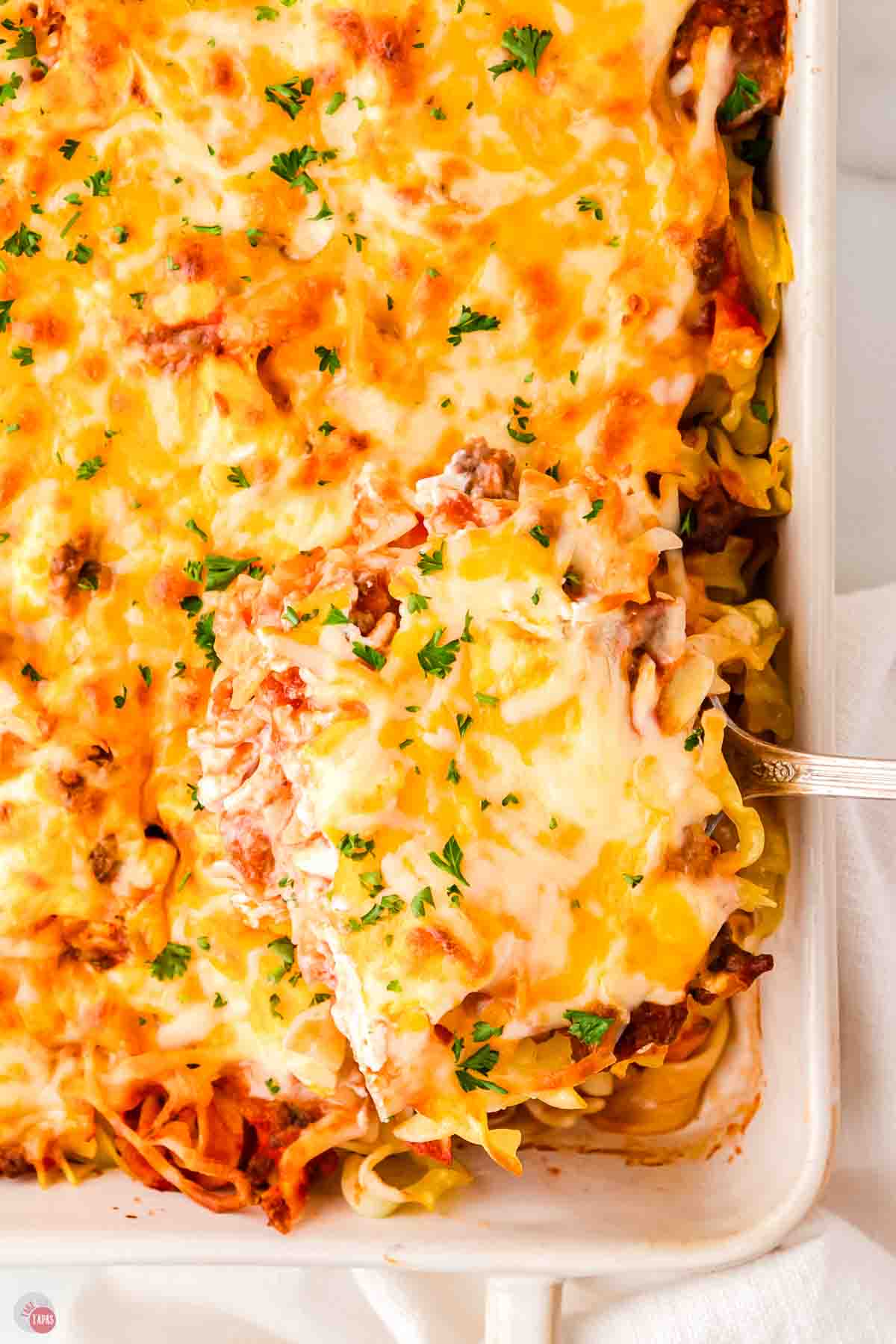 ground beef recipe with noodles and cheese and a scoop being removed