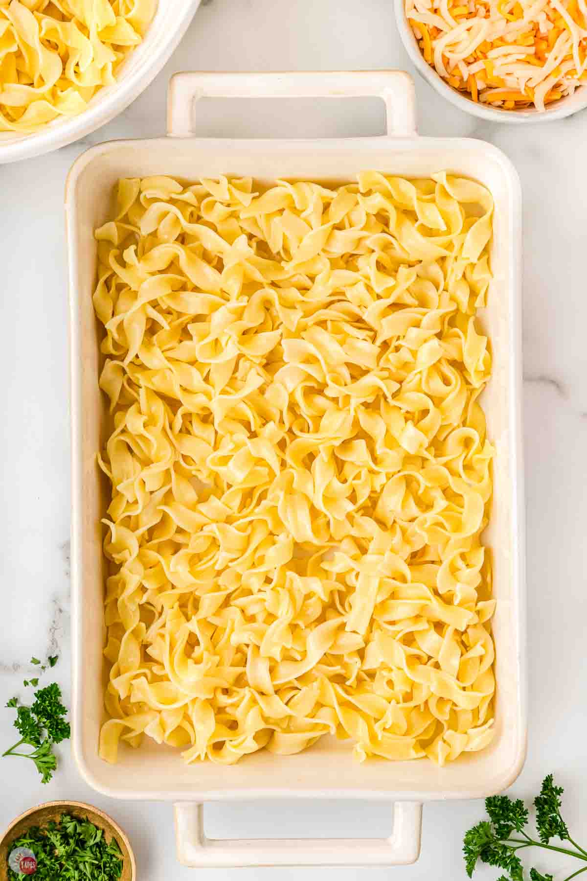 cooked egg noodles in a white baking dish