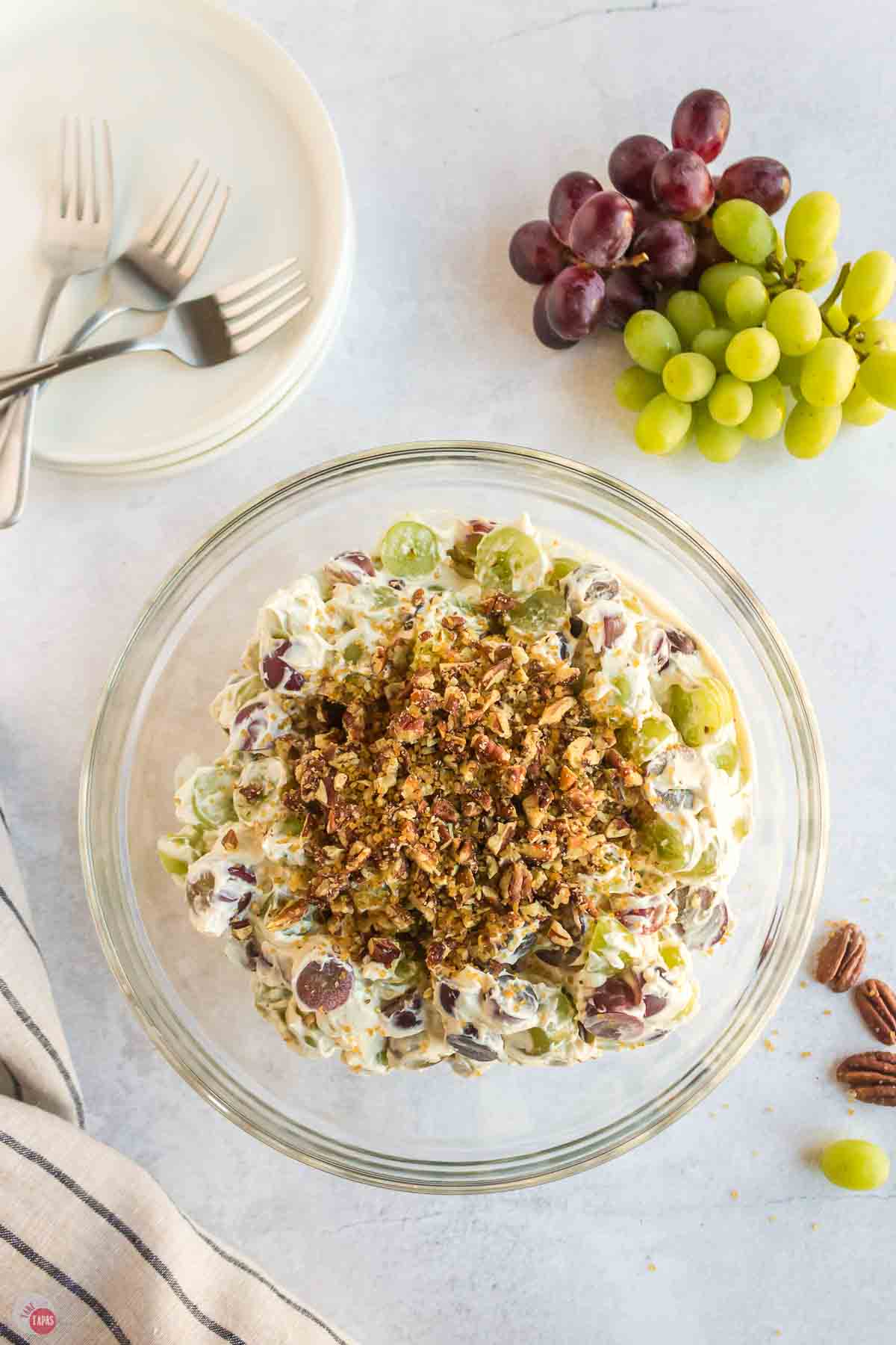 bowl of grape salad sprinkled with chopped pecans on top