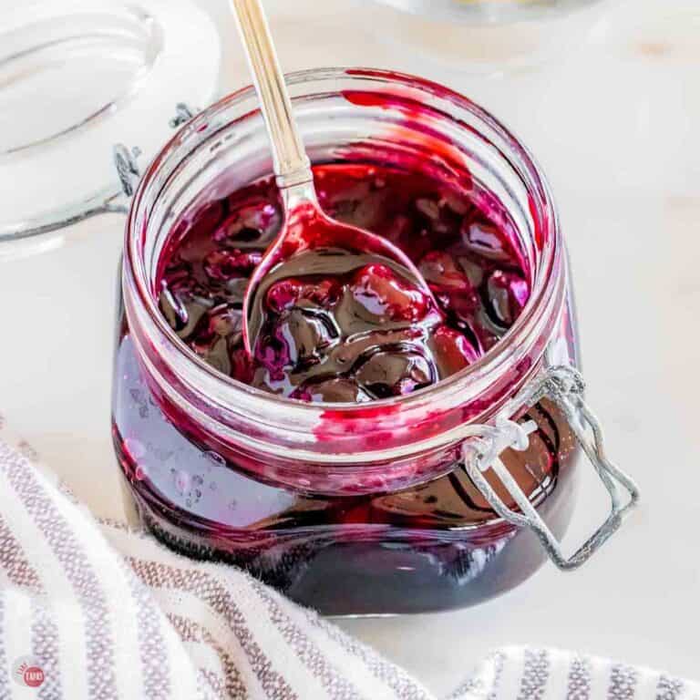clear mason jar of cherry pie filling with a spoon in it