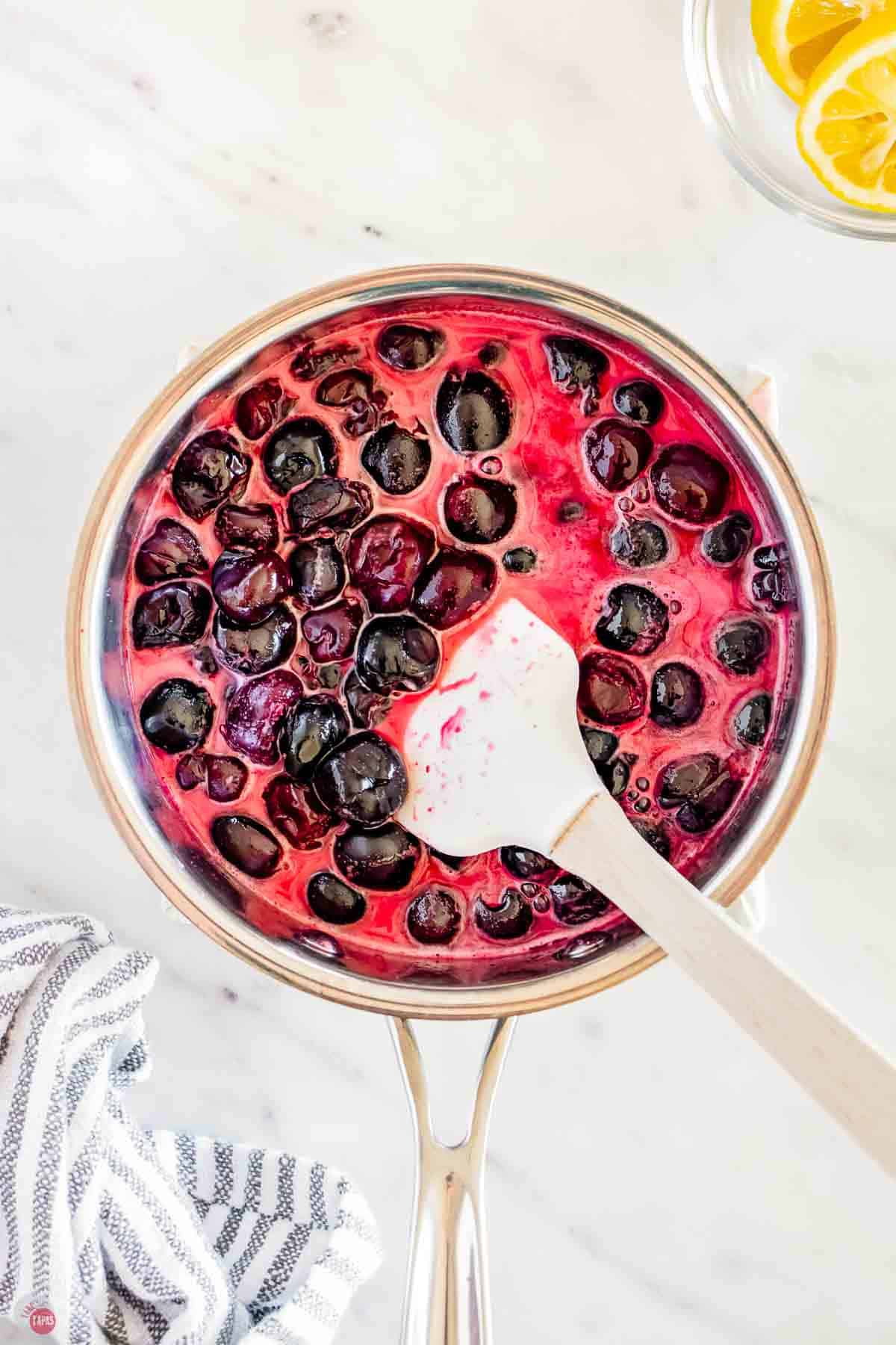 cherries boiling in a silver pot