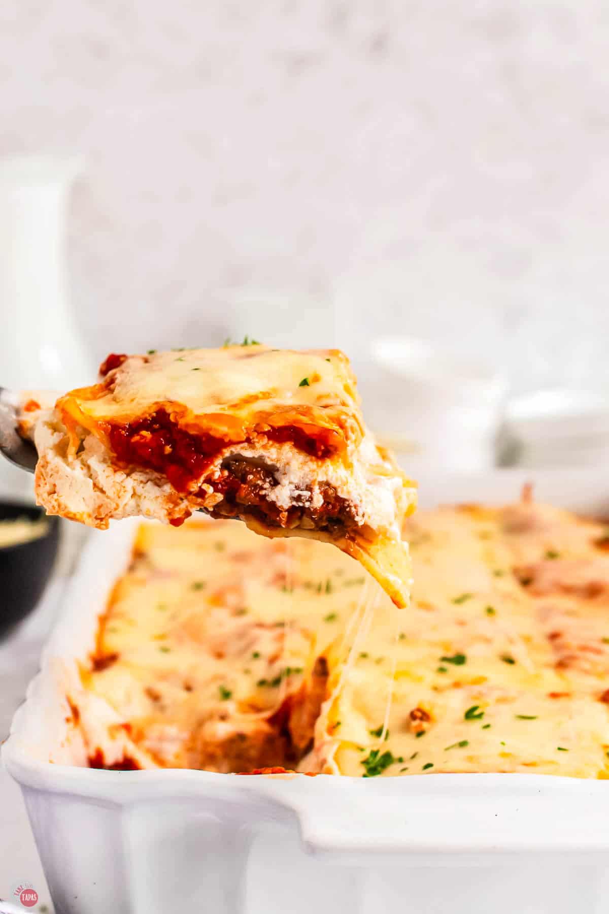 spatula scooping out some lasagna from a dish