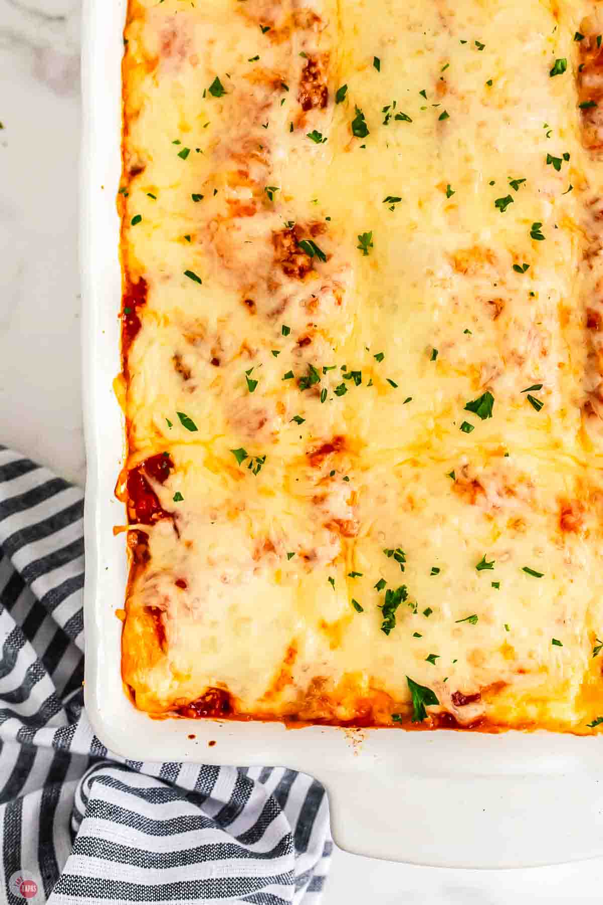 baking dish of classic lasagna topped with chopped parsley