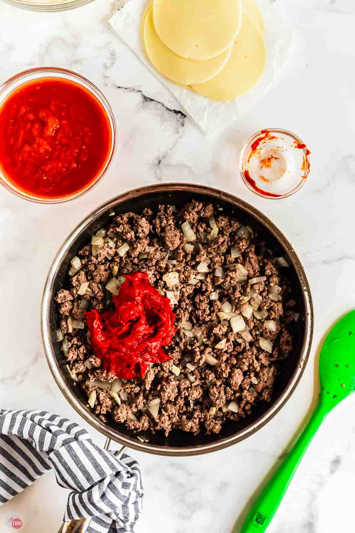 cooked ground beef and tomato paste in a skillet