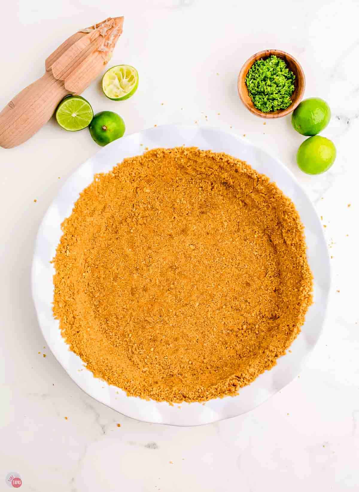 graham cracker crust in a white pie plate