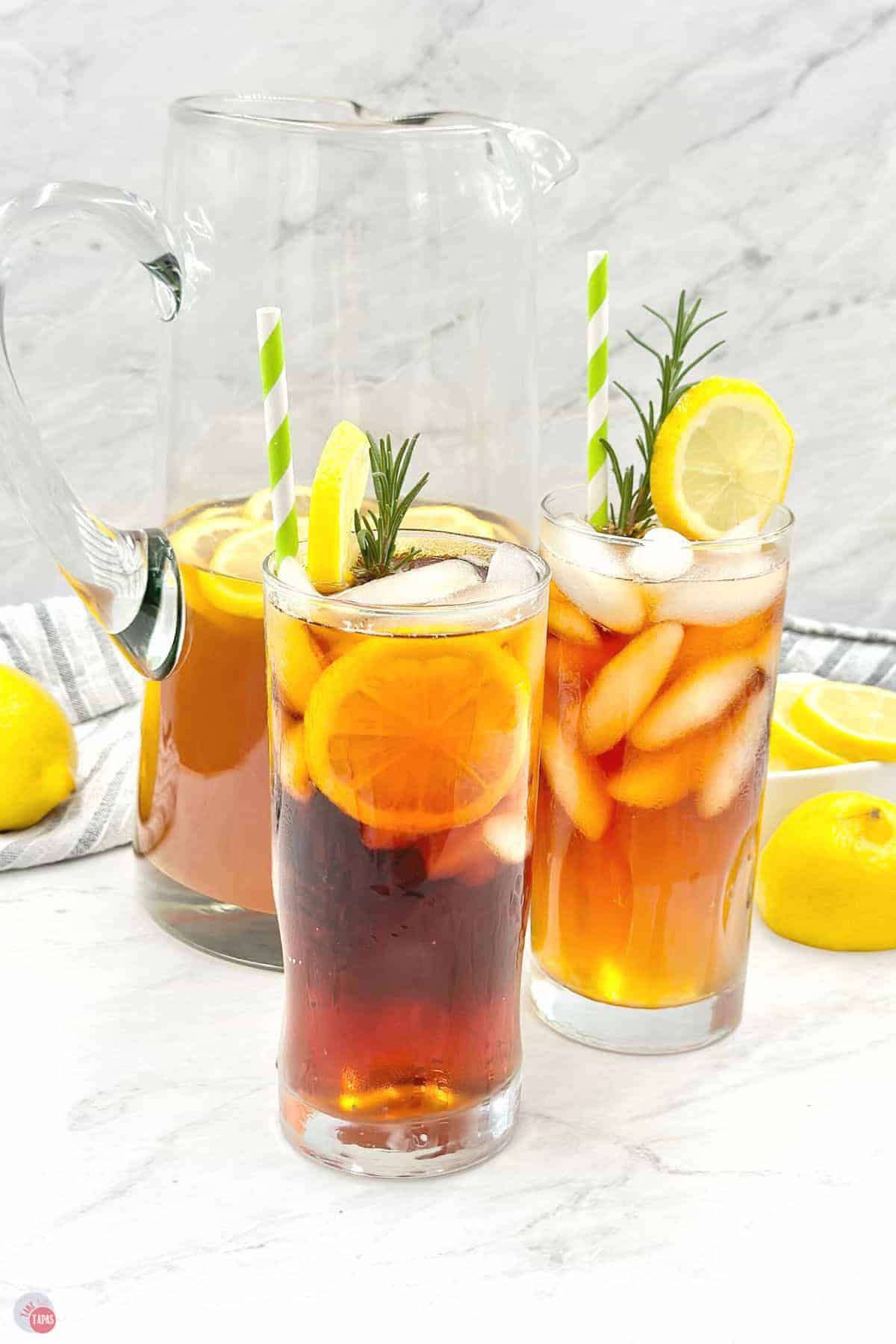 glasses and a pitcher all full of iced tea with lemon