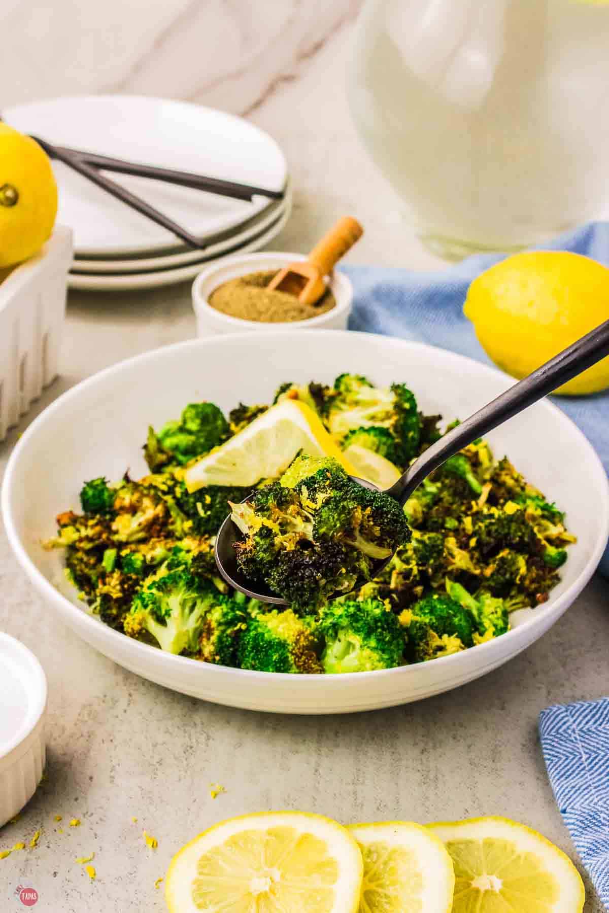 bowl of broccoli with a silver spoon scooping some out