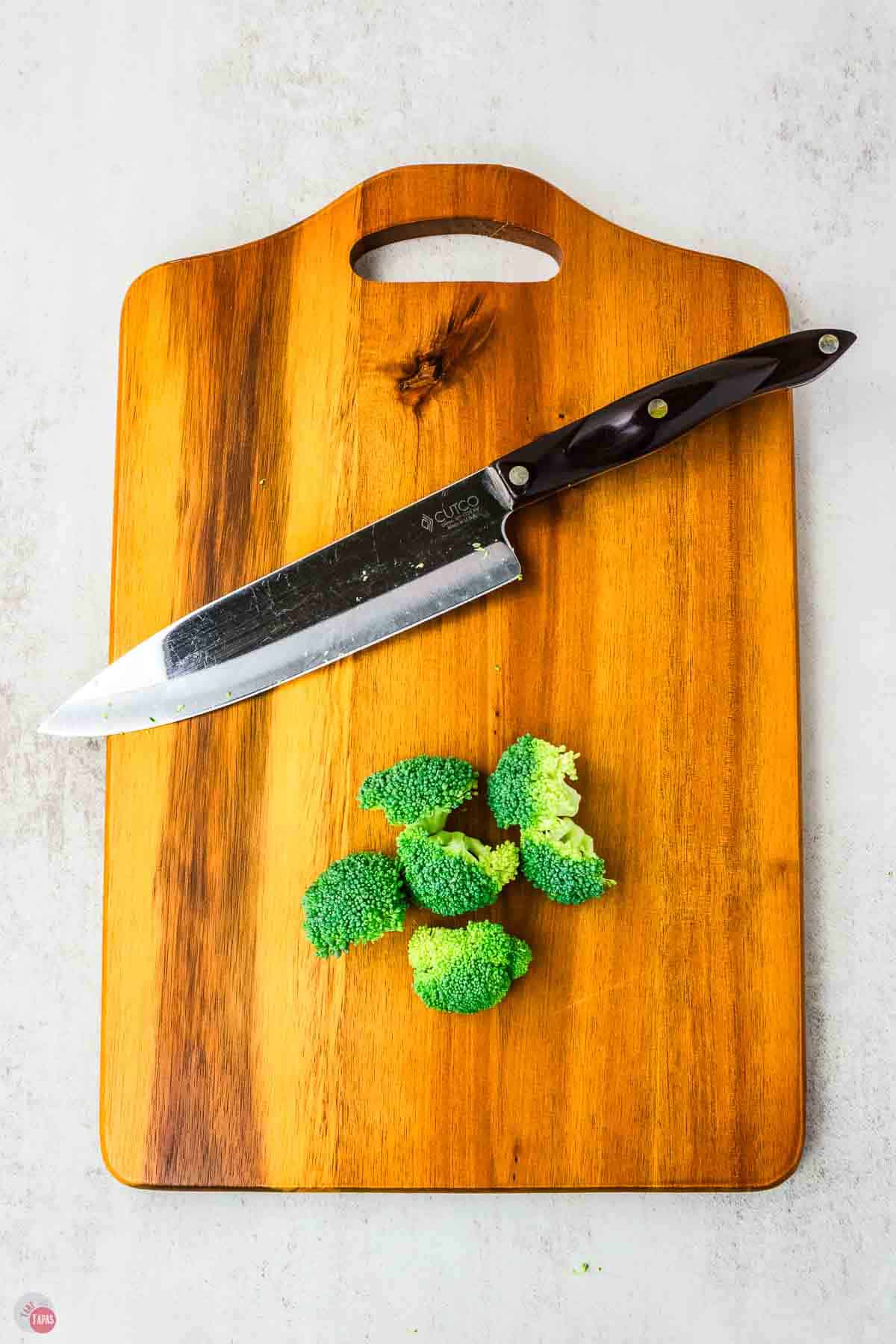cutting board with knife and broccoli florets