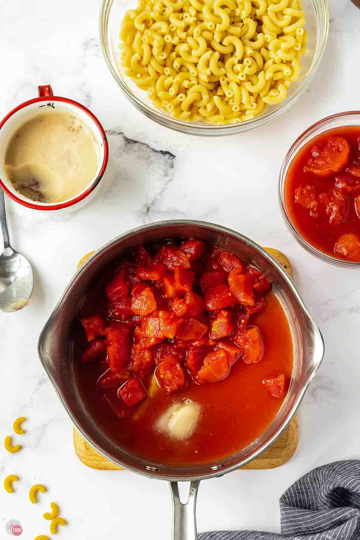 silver pot with tomatoes and bacon fat in it