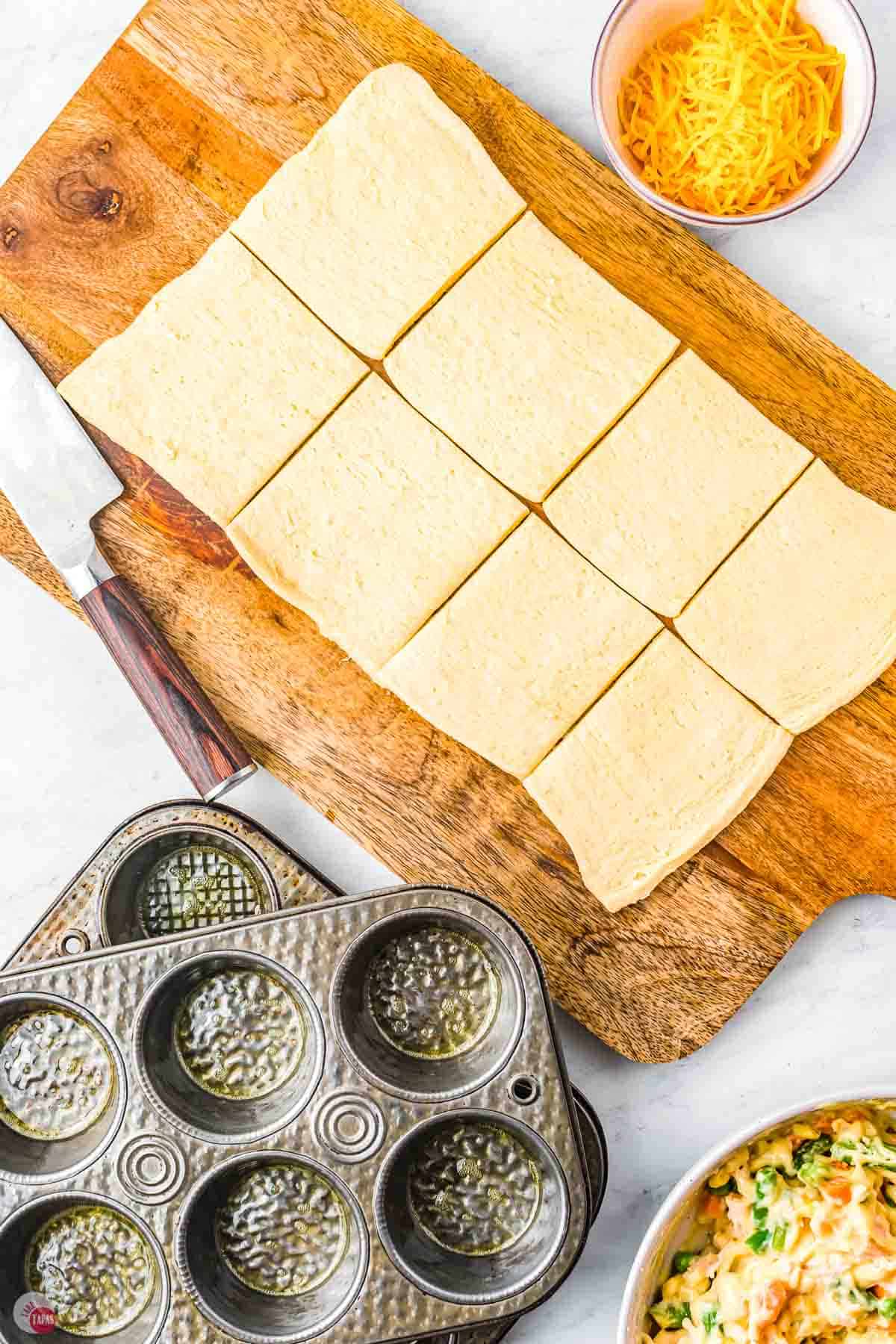 crescent roll dough being cut into squares