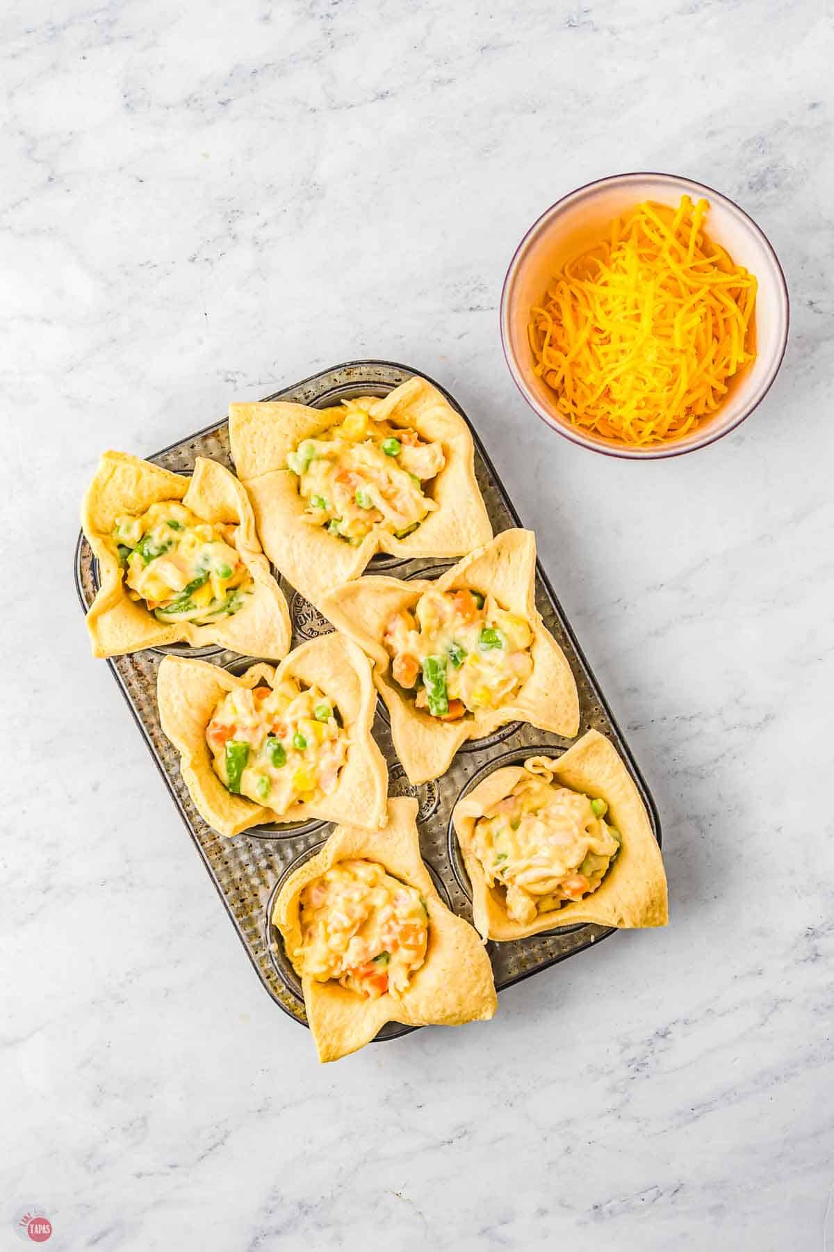 muffin pan with dough and filling
