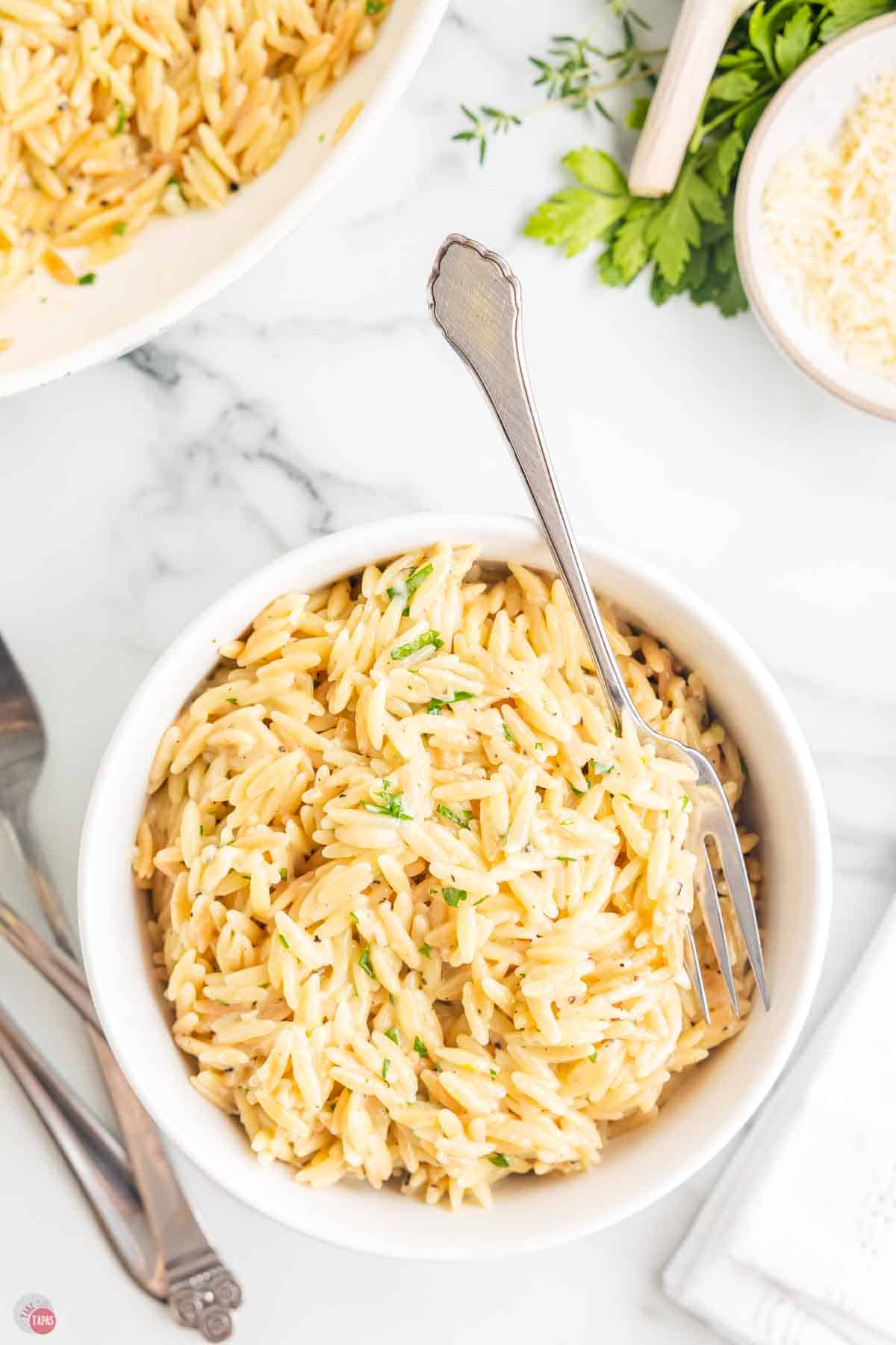 bowl of parmesan orzo with a fork in it