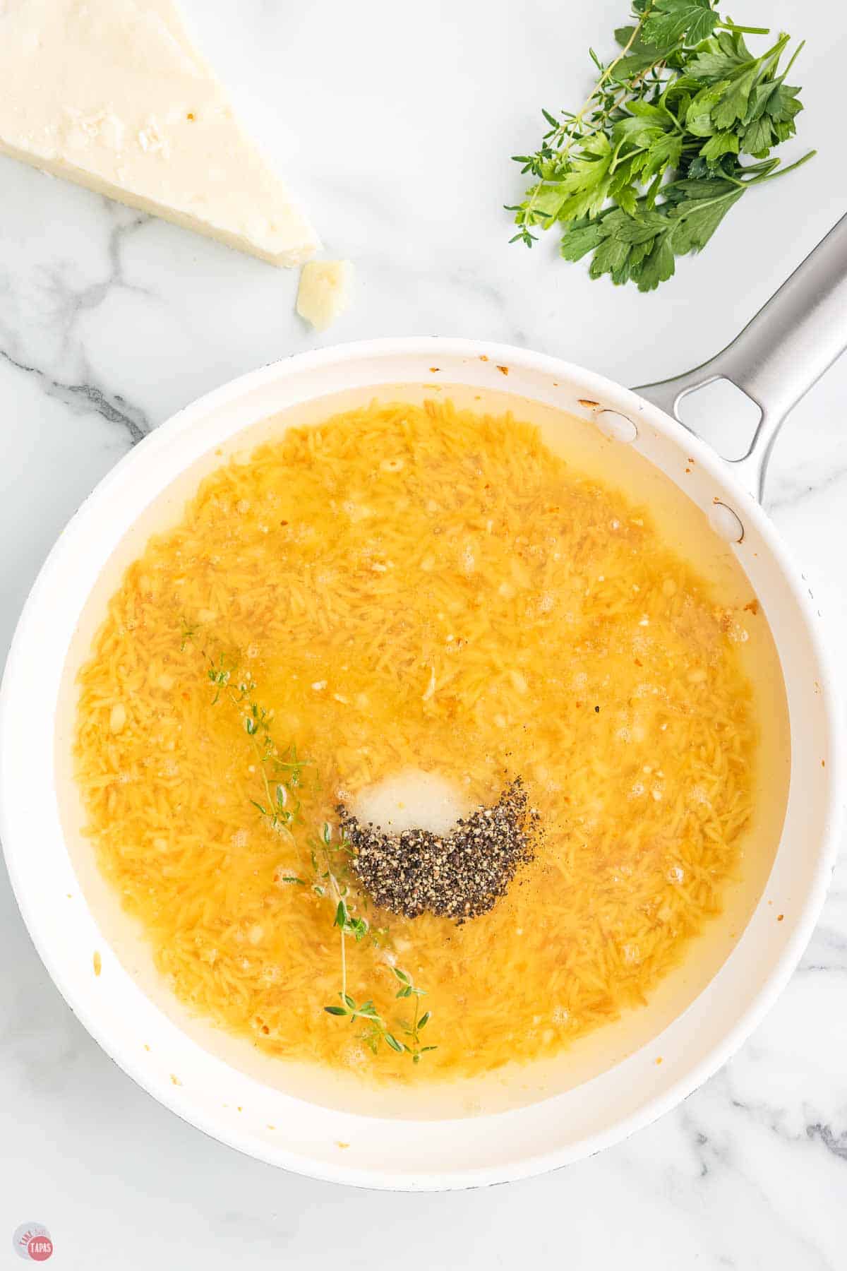 pasta noodles and broth simmering in a skillet