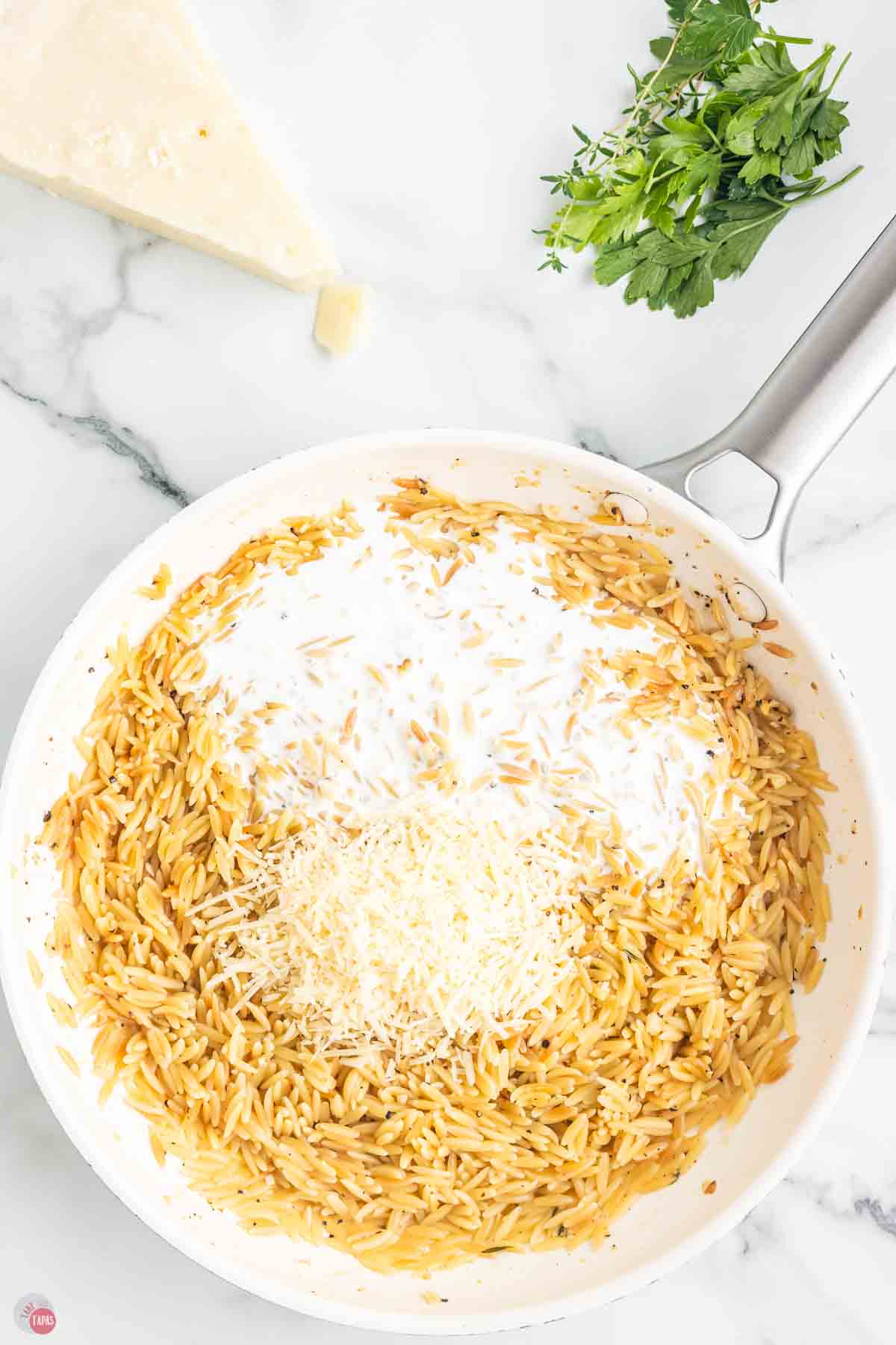 orzo and cheese in a skillet with pasta