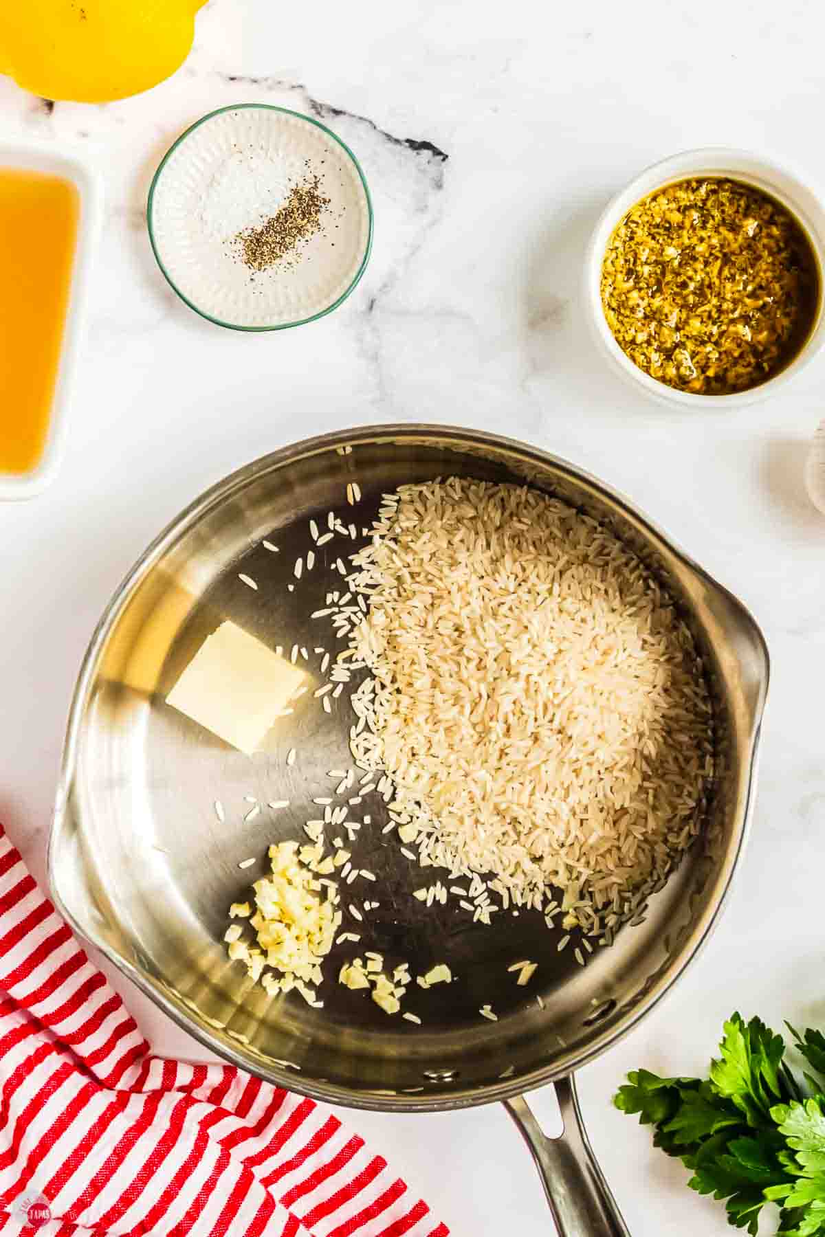 rice, butter, and garlic in a silver pot