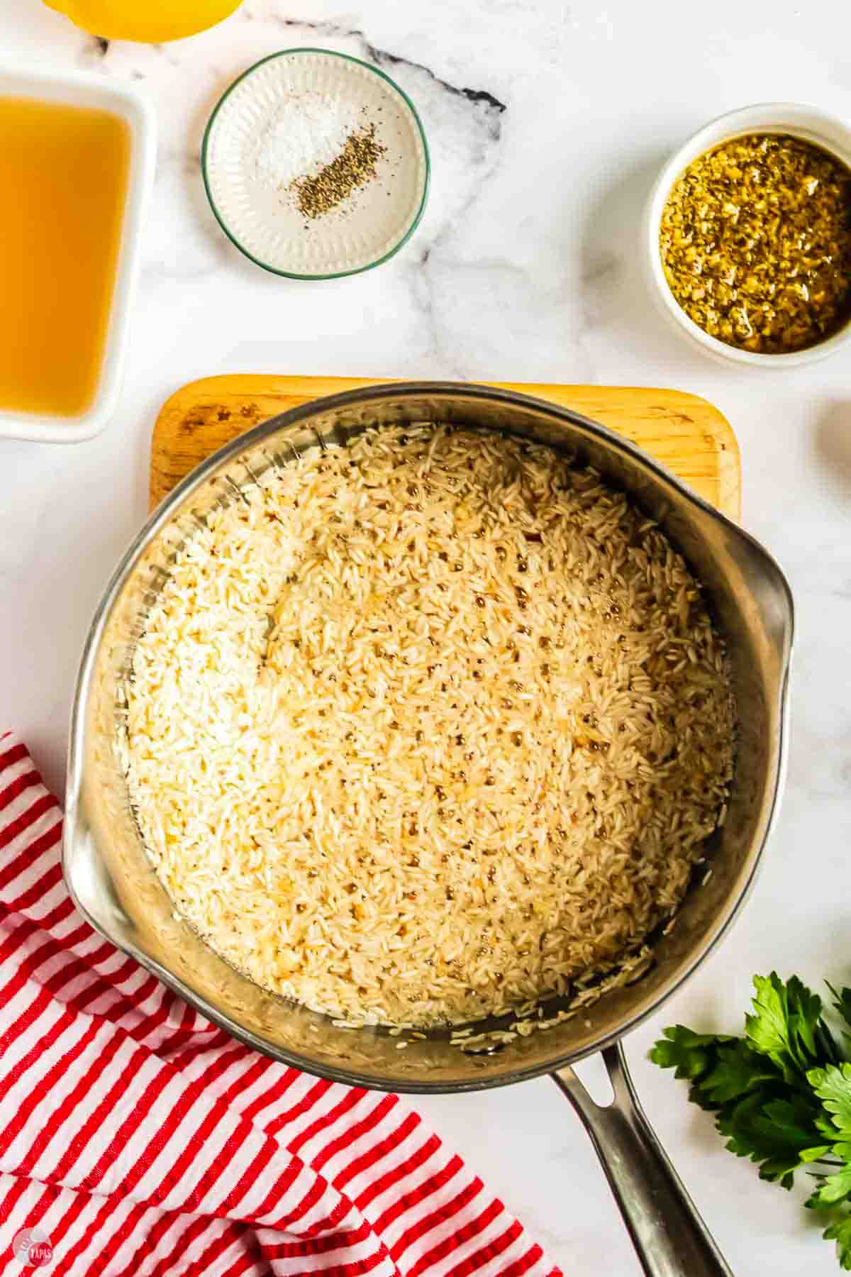 white rice toasting in a silver pot