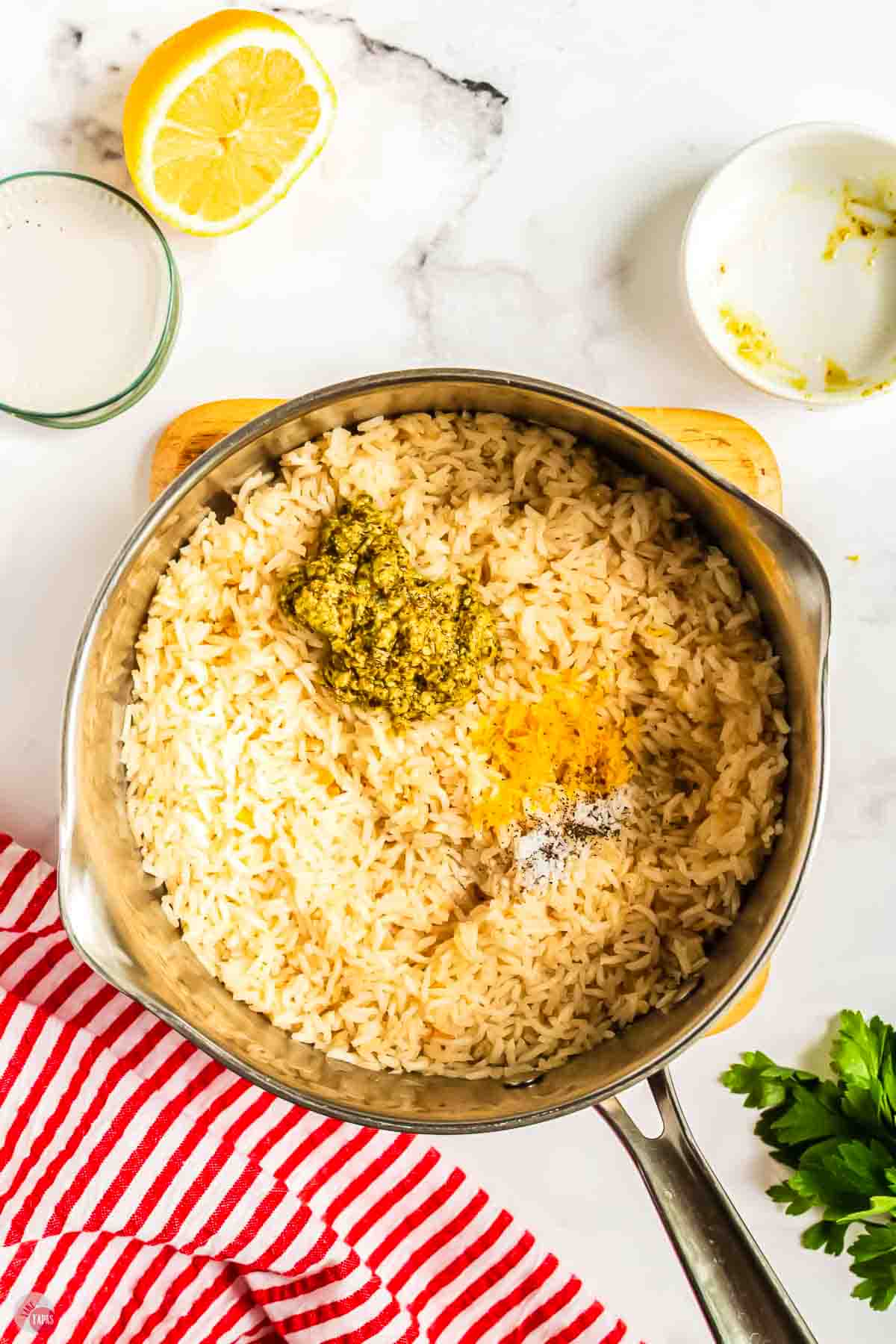 cooked rice in a pot topped with lemon zest and pesto
