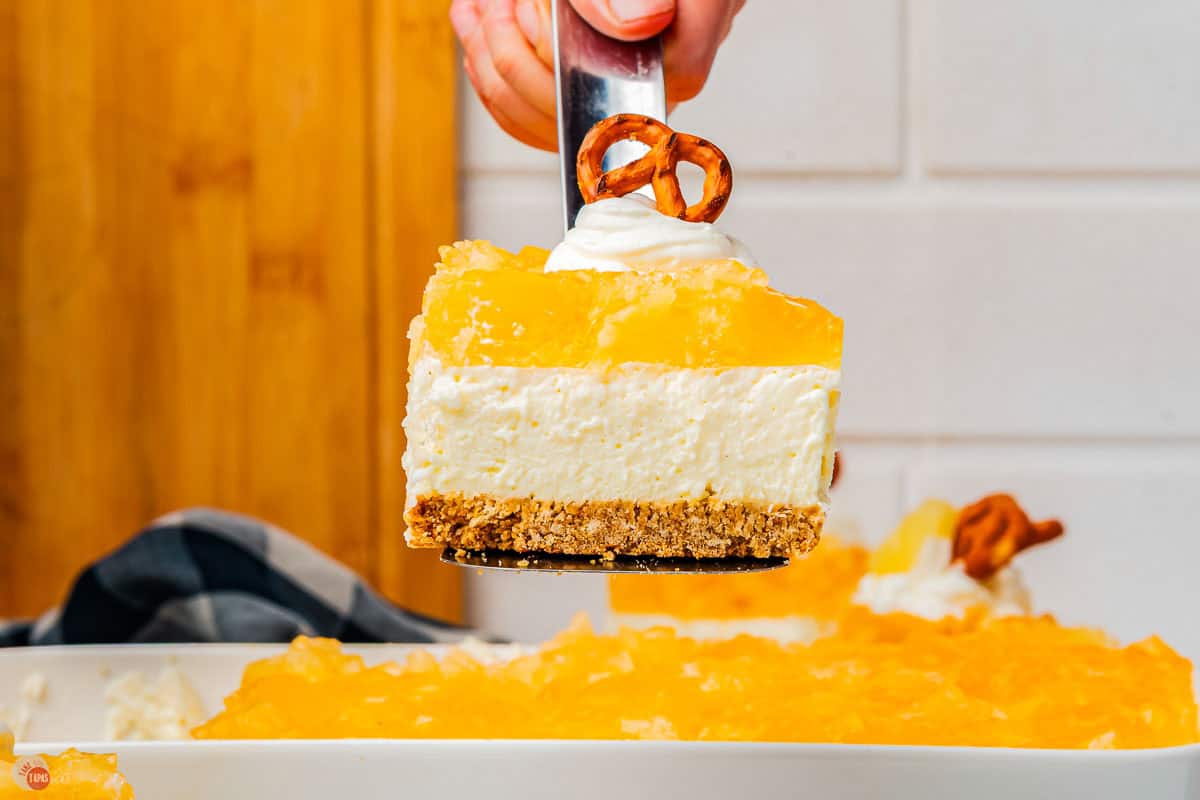 spatula holding a slice of pineapple pretzel salad