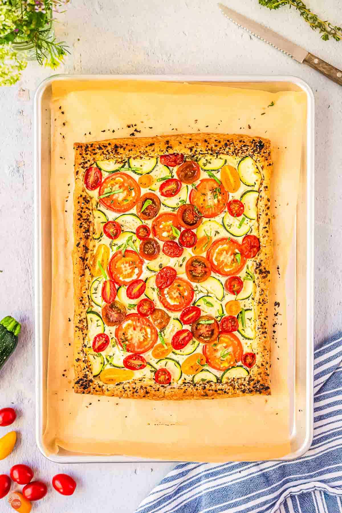 tomato zucchini tart on a baking sheet with parchment paper