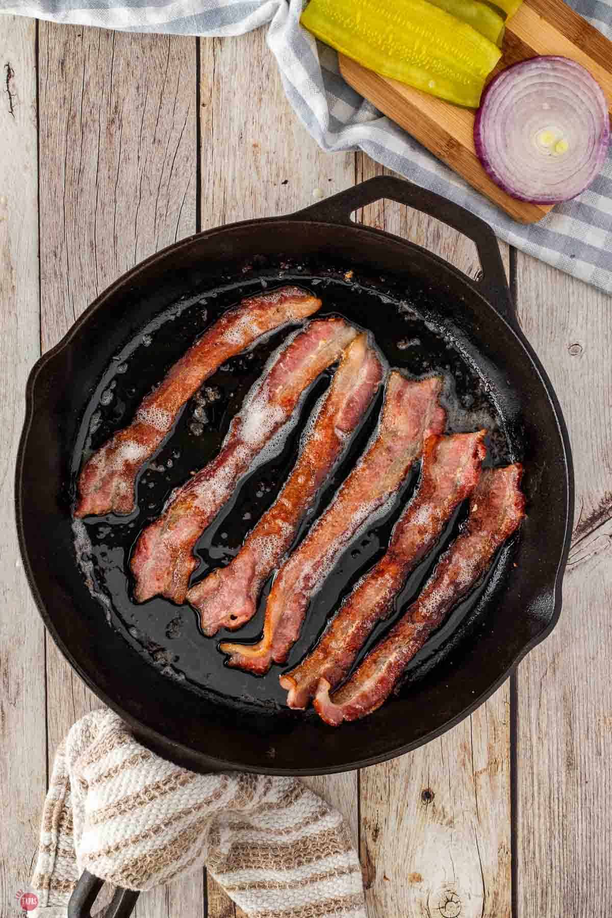 bacon cooking in a cast iron skillet