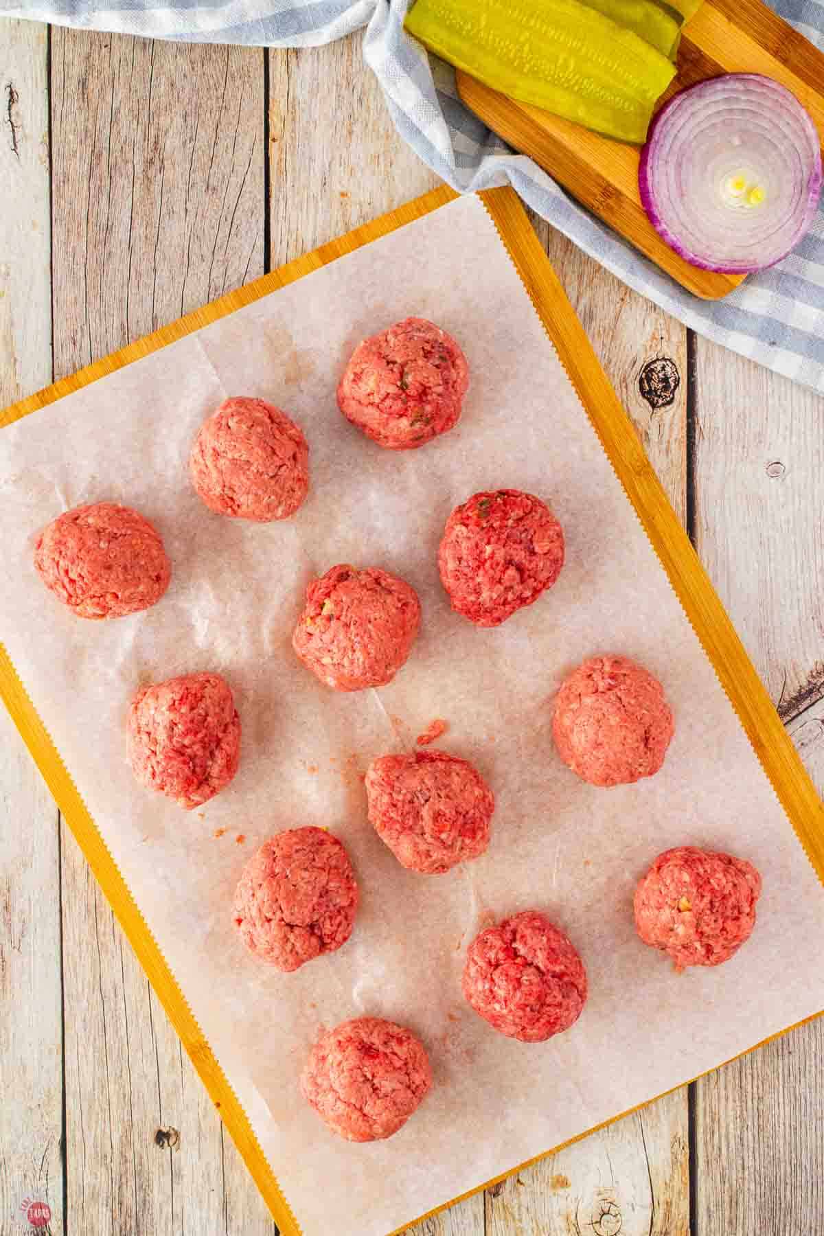 small balls of ground beef on a piece of parchment paper