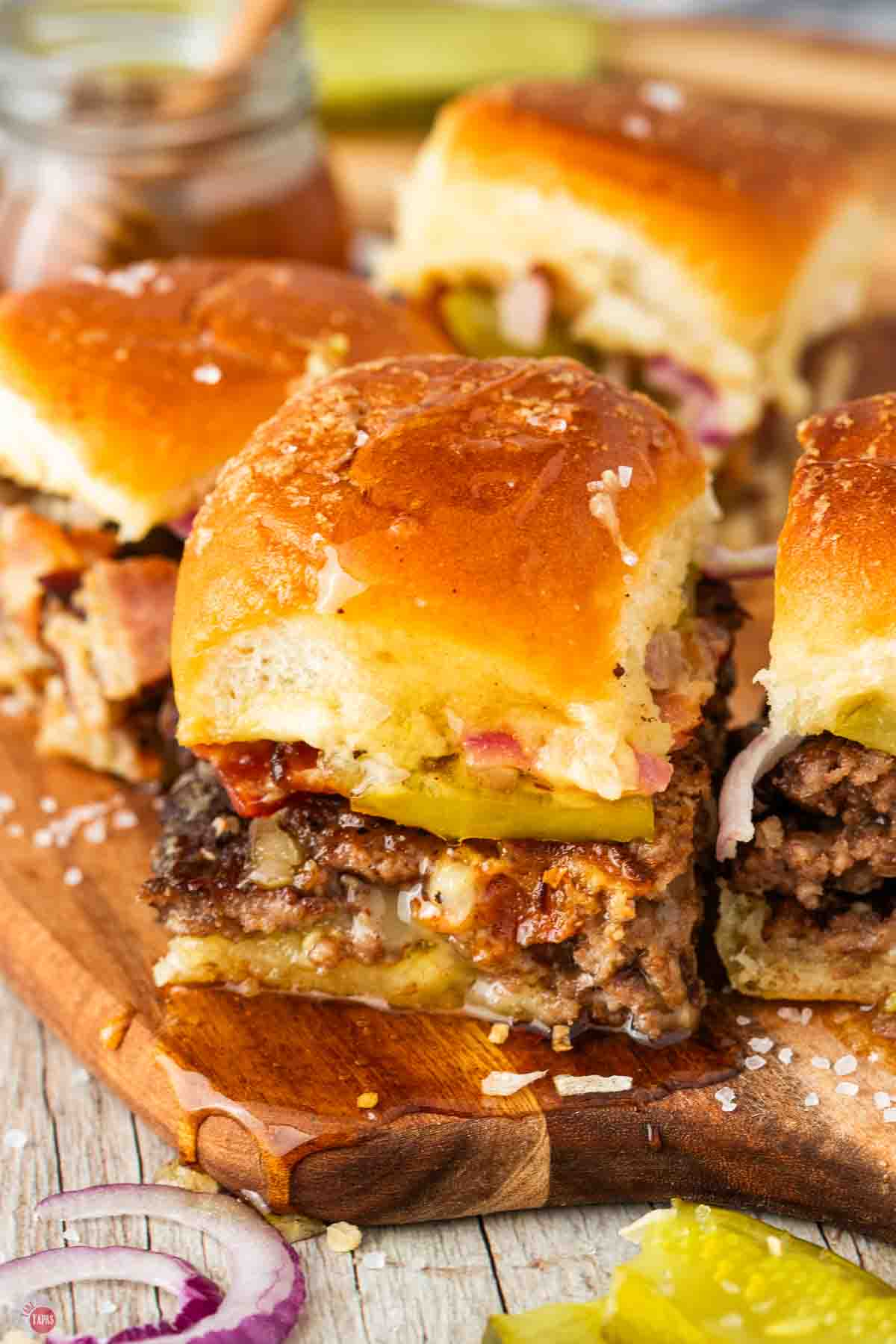 bacon smash burger sliders on a wood board
