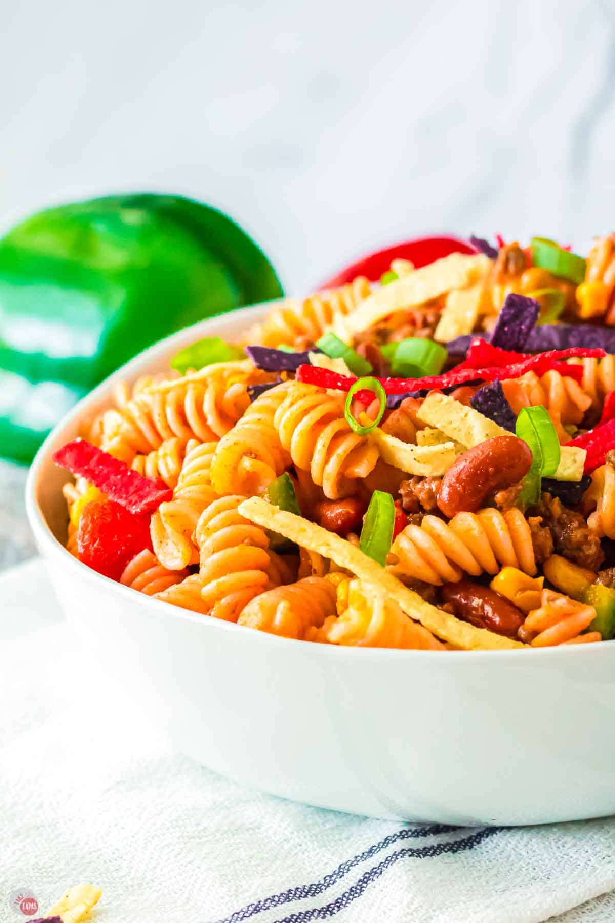 close up of a white bowl filled with pasta and tortilla strips