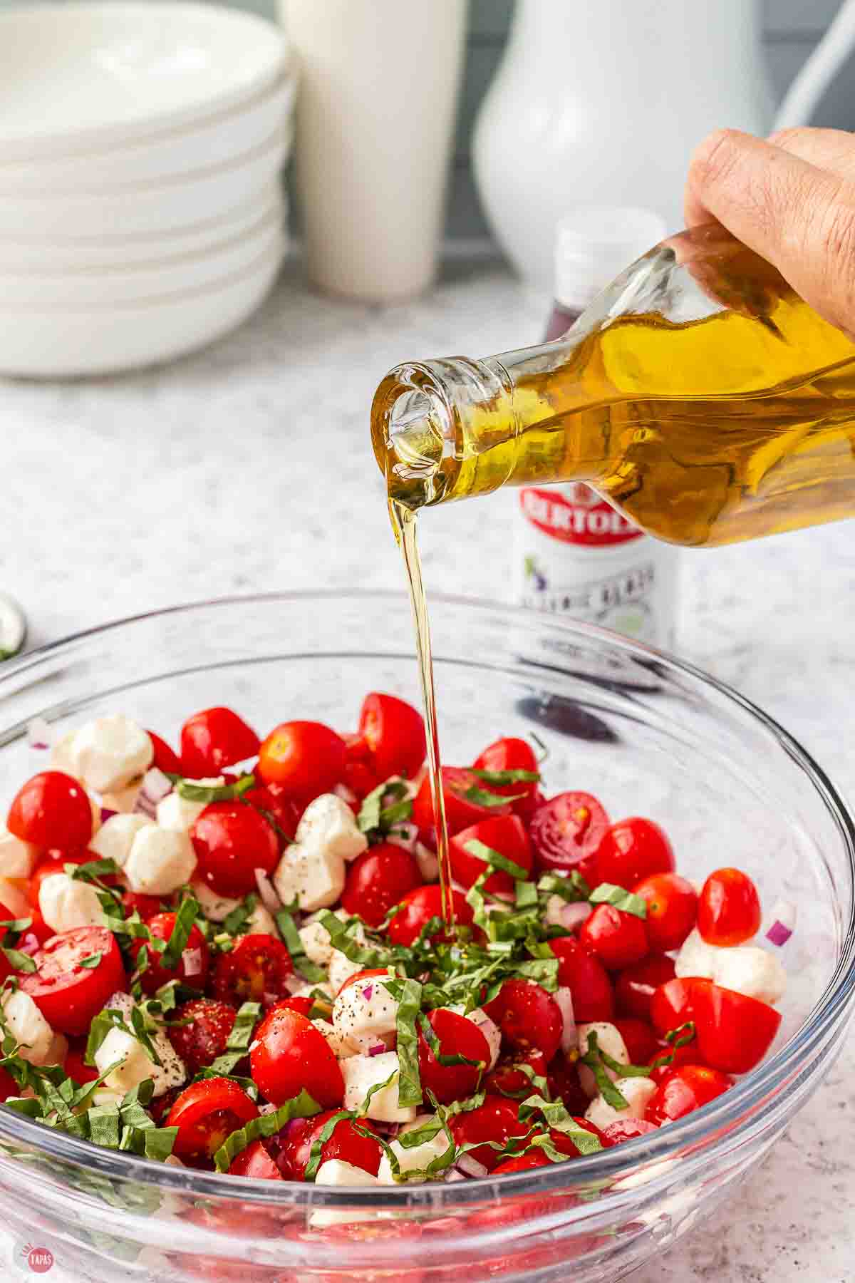 olive oil being drizzled on top of vegetables