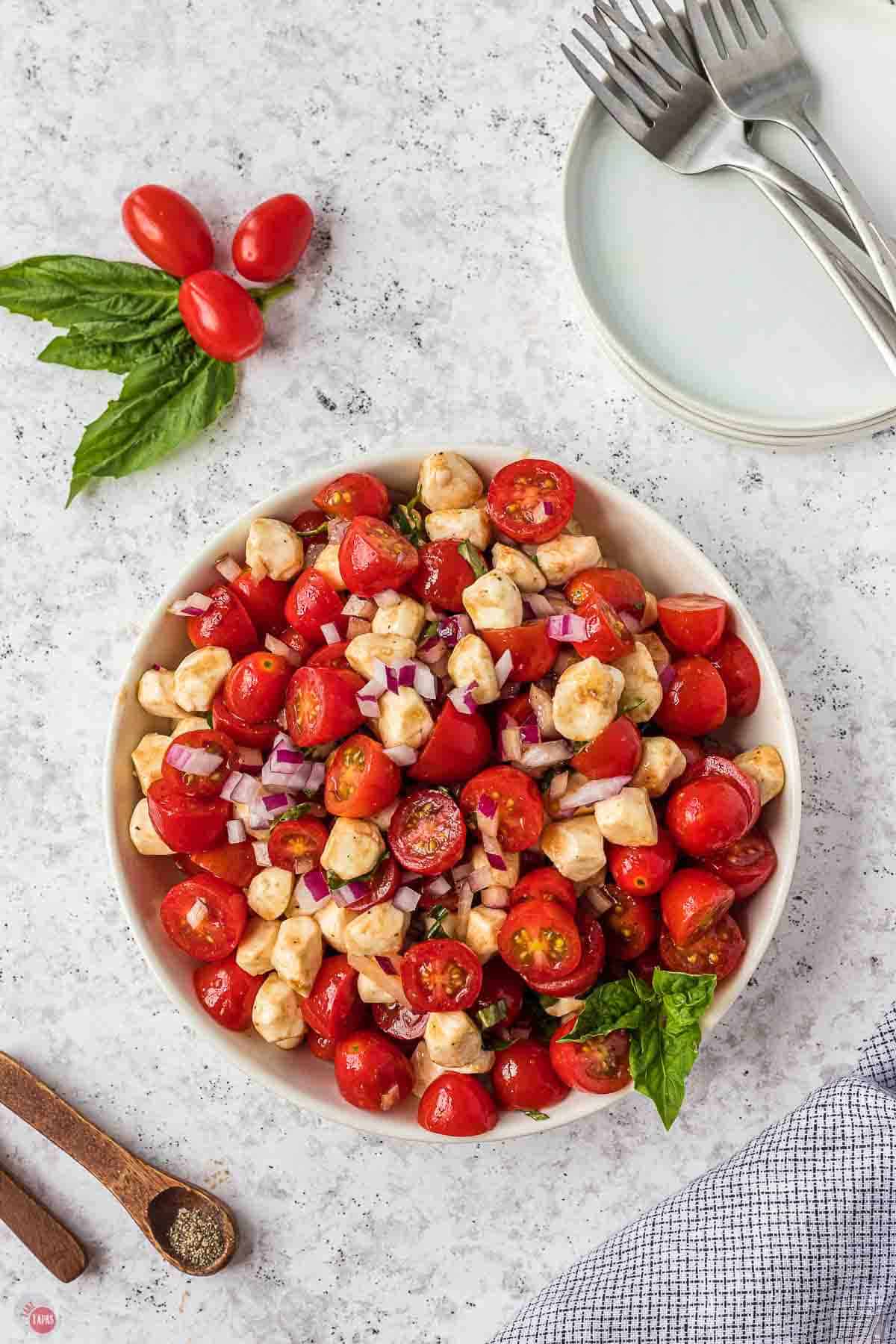 bowl of tomato mozzarella salad topped with balsamic glaze