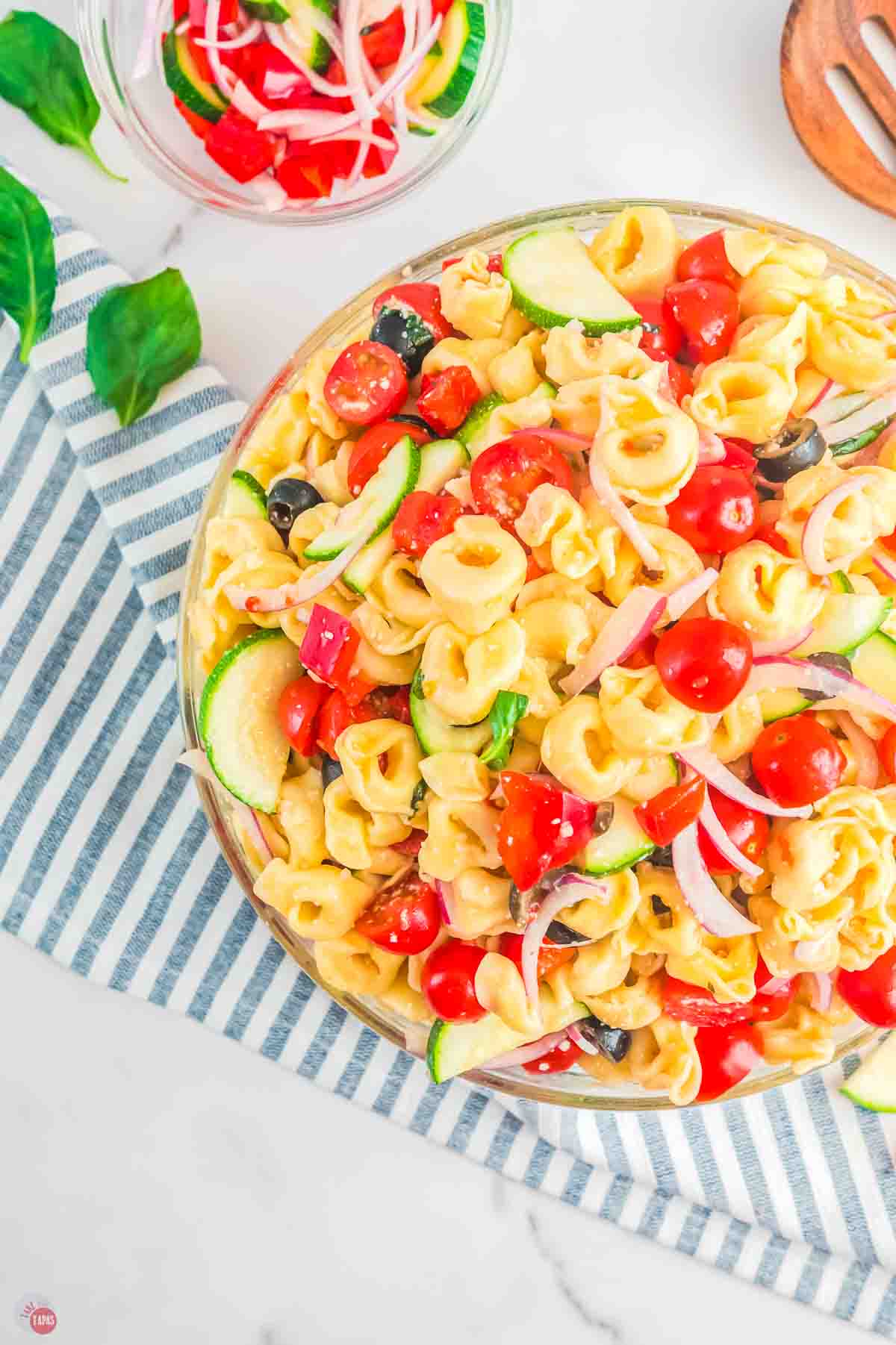 bowl of tortellini pasta salad with a striped napkin
