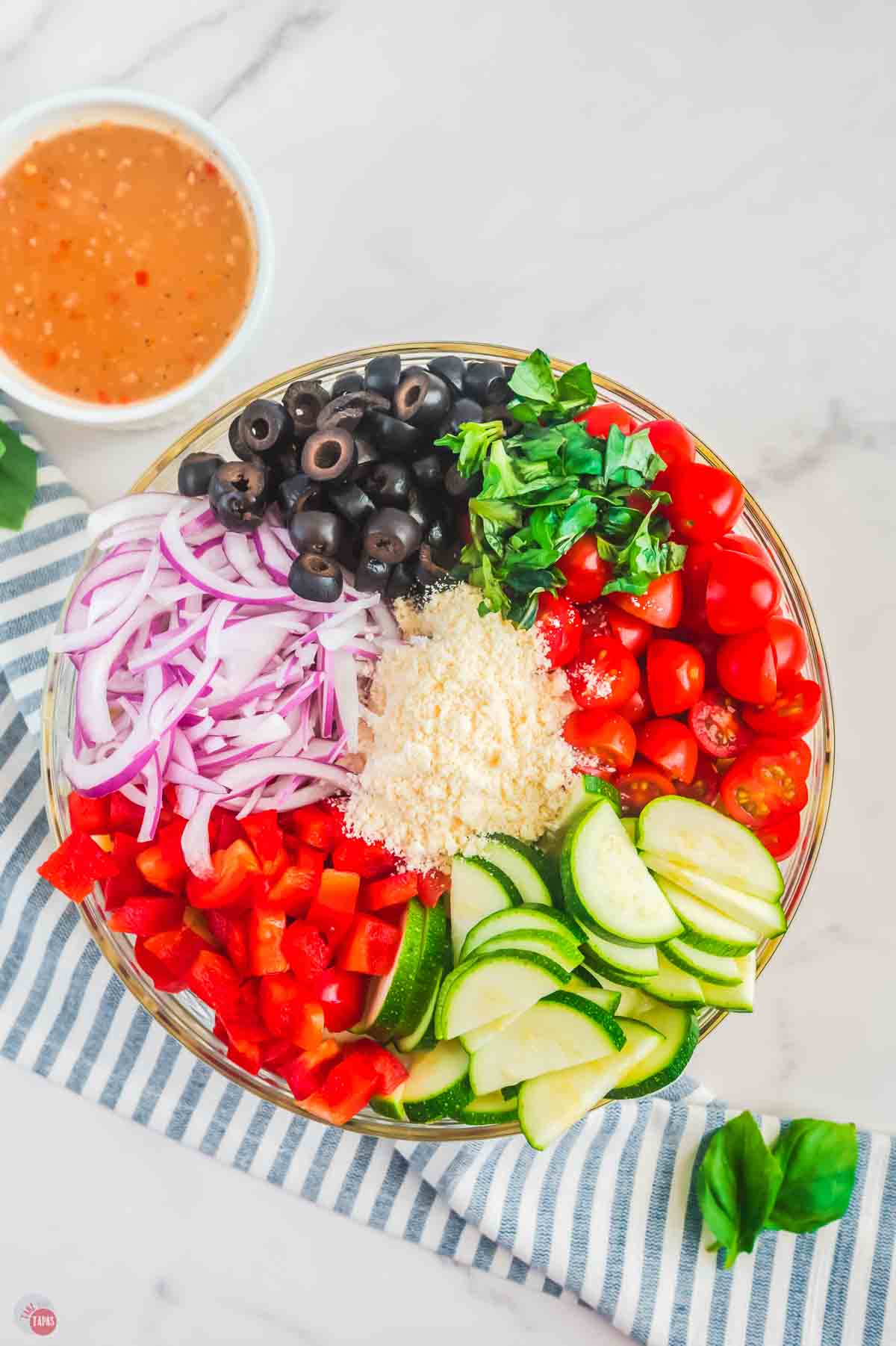large, clear bowl with small mounds of chopped vegetables