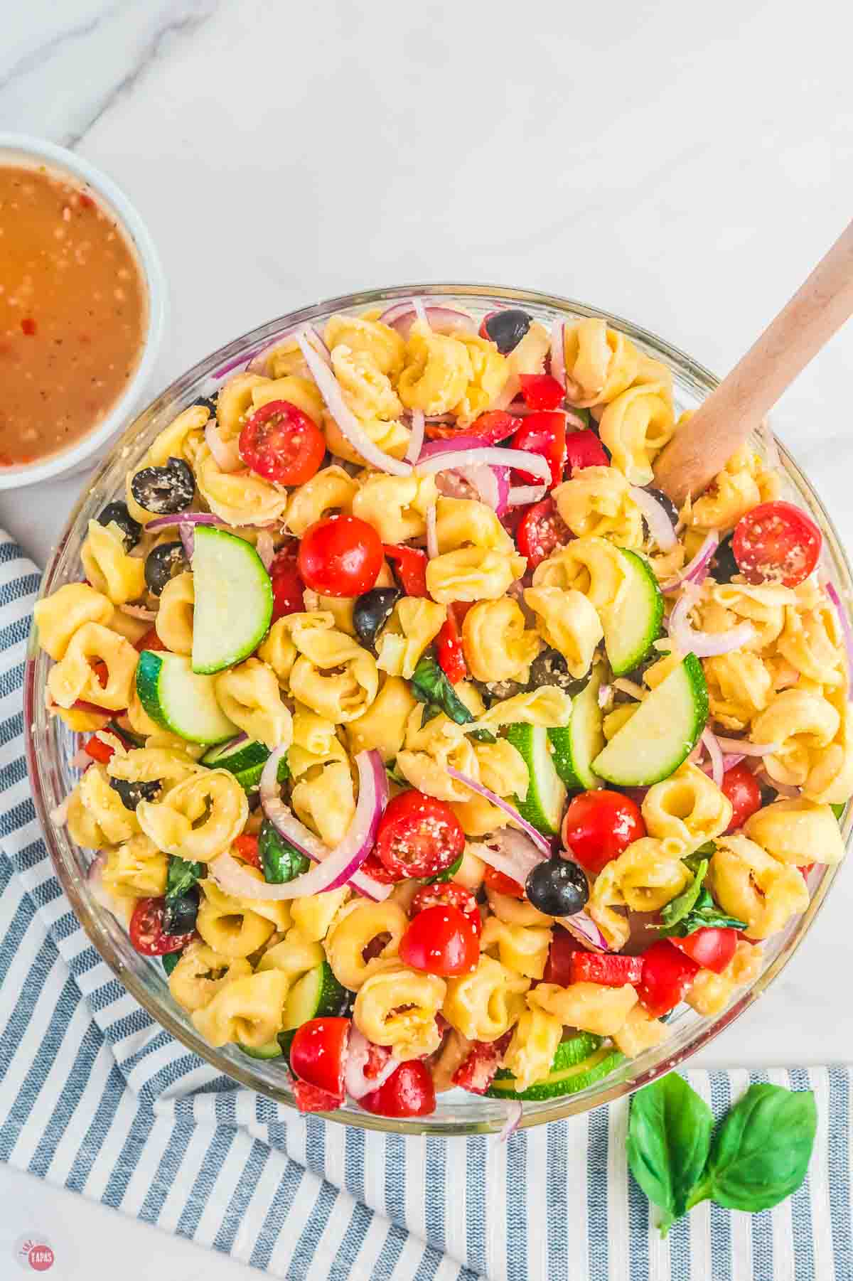 bowl of pasta salad with tomatoes and olives